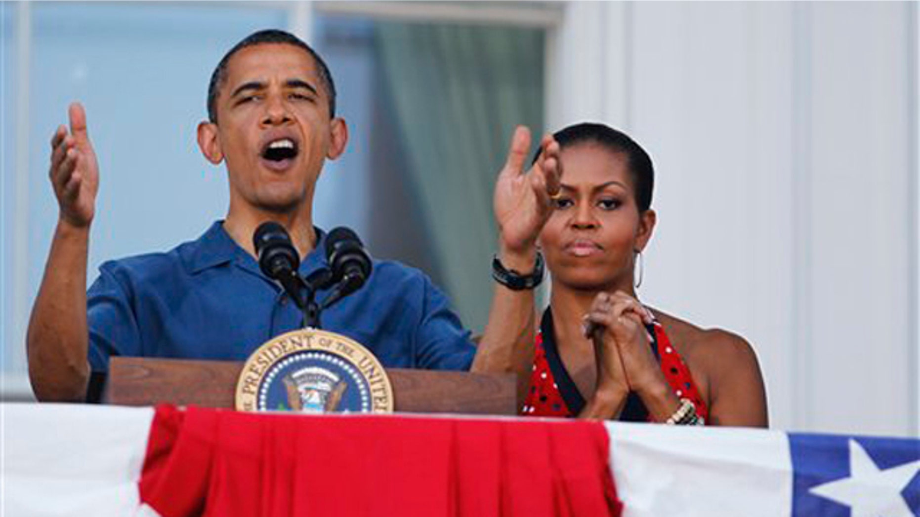 President Obama with first lady Michelle Obama, right, delivers his remarks from the White House's Blue Room balcony for an Independence Day celebration July 4 in Washington. (AP Photo)