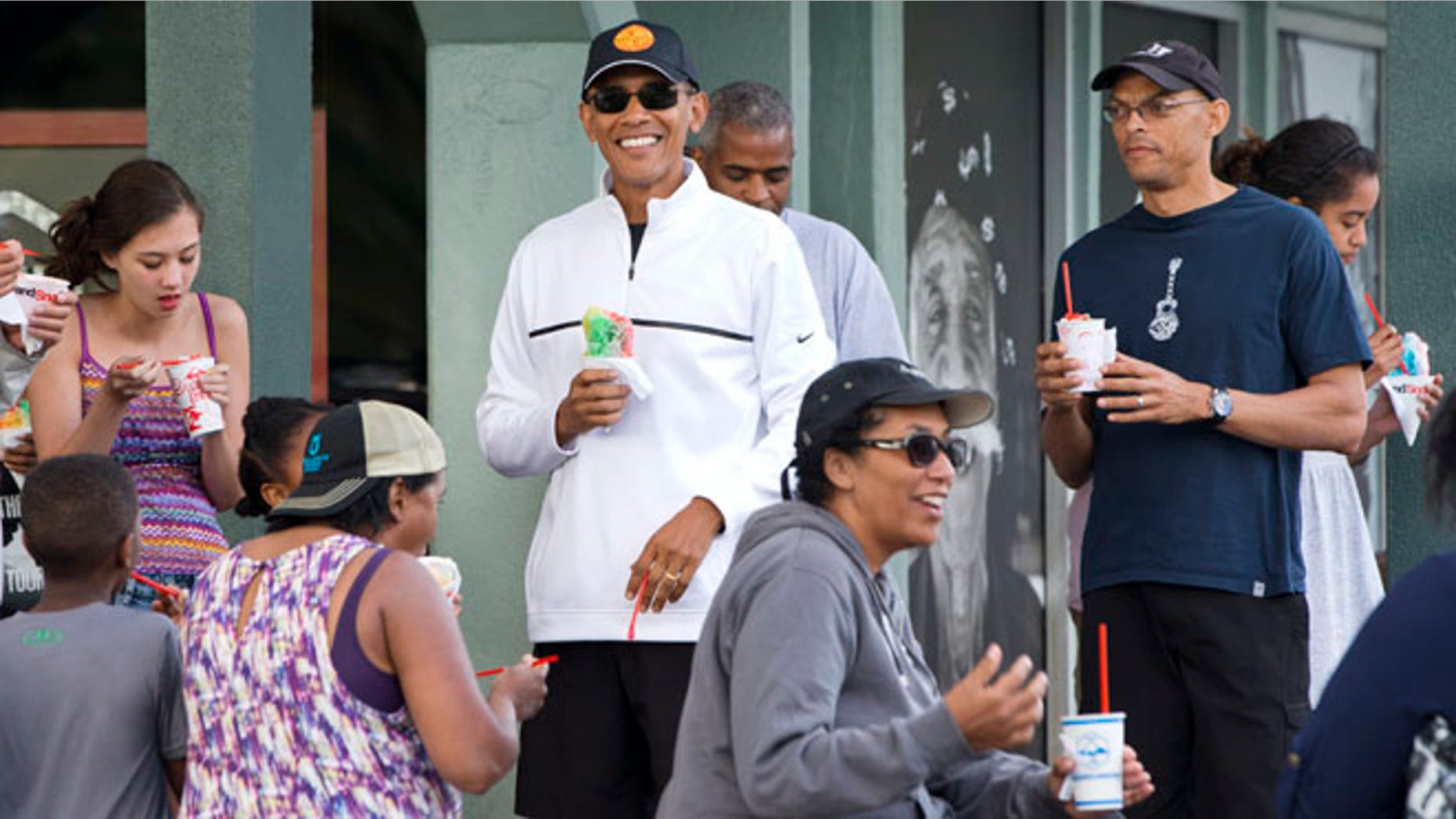 Jan. 1, 2015: President Obama smiles as he eats shave ice with friends and his daughters in Kailua, Hawaii.