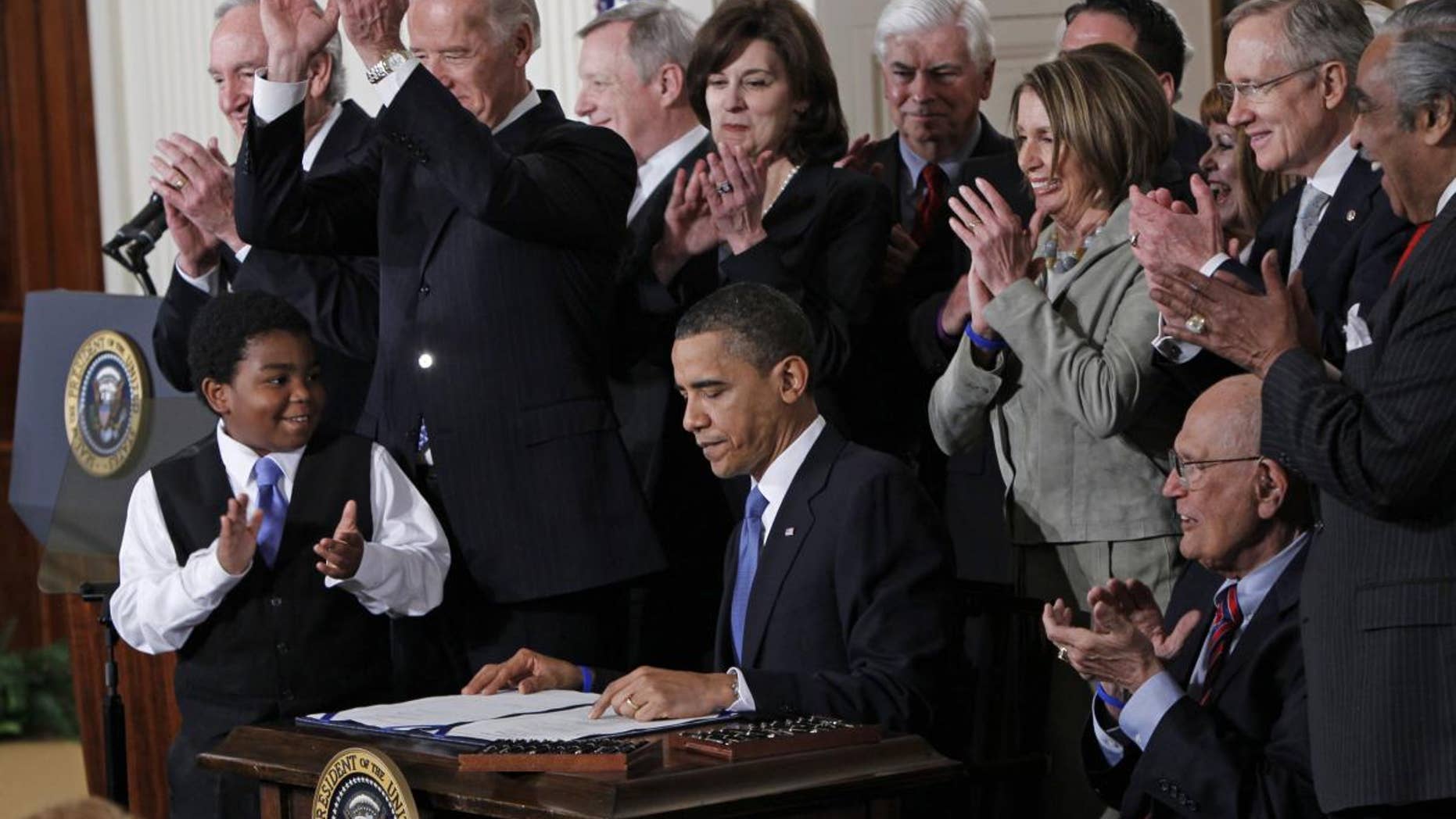 In this March 23, 2010 file photo, President Barack Obama is applauded after signing the health care bill in the East Room of the White House in Washington. (AP Photo/Charles Dharapak, File)