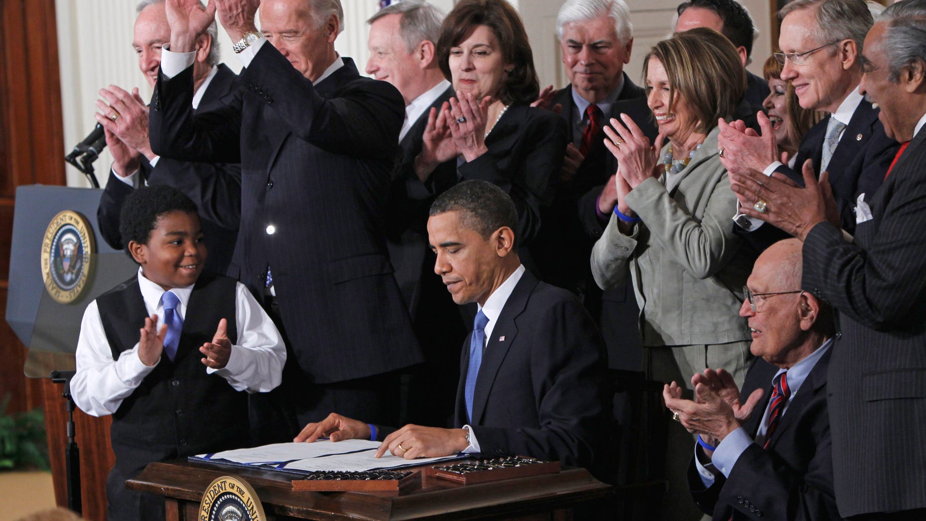 In this March 23, 2010 file photo, President Barack Obama is applauded after signing the health care bill in the East Room of the White House in Washington