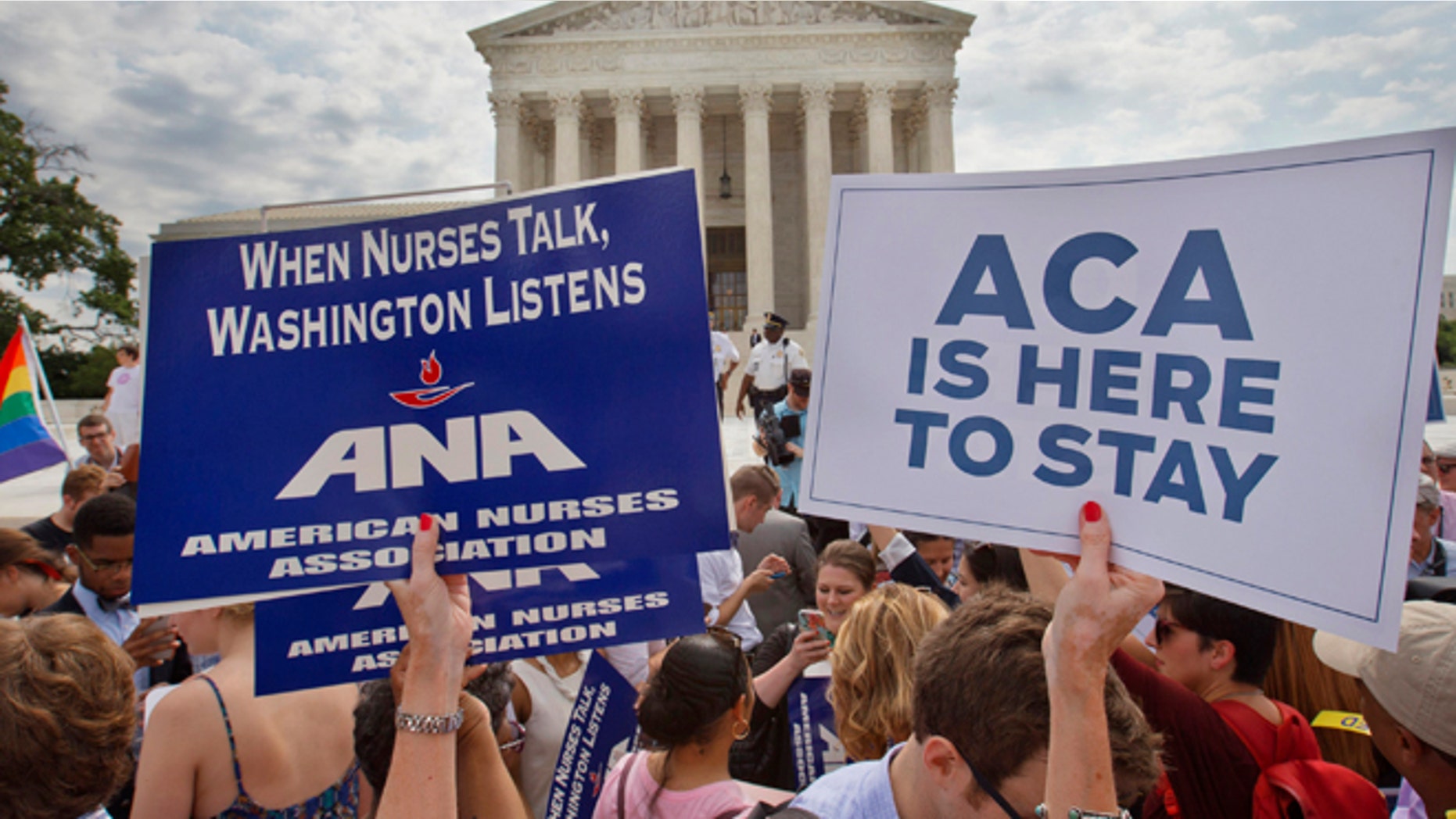 June 25, 2015: Supporters of the Affordable Care Act hold up signs as the opinion for health care is reported outside of the Supreme Court in Washington. (AP)