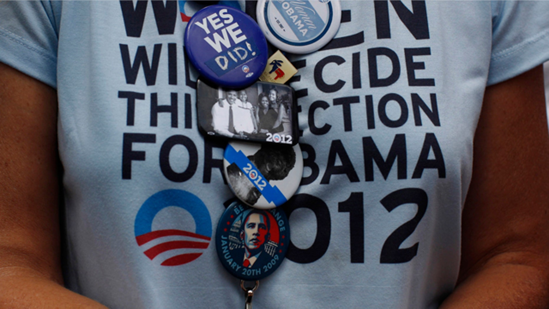 A supporter of Obama wears a collection of badges in the audience during a 2012 election campaign rally in Colorado Springs.