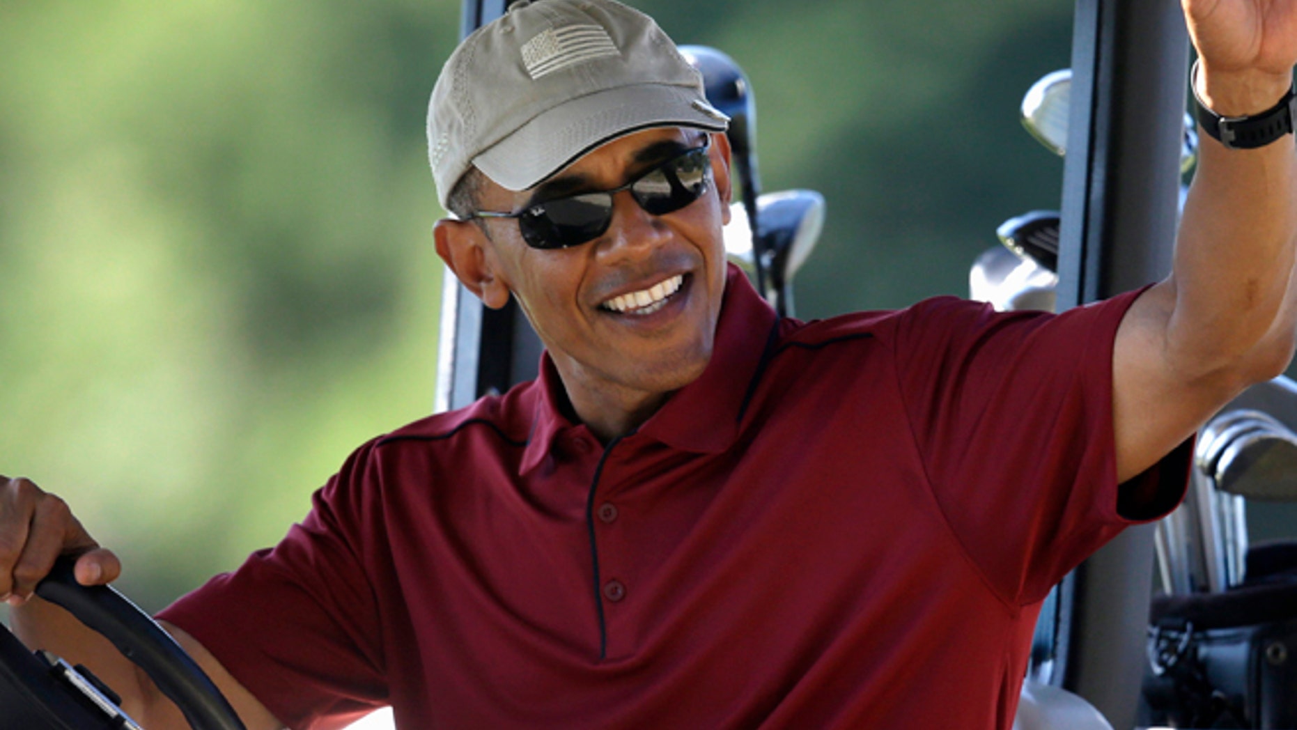 Aug. 14, 2015: President Barack Obama waves from a golf cart while golfing at Farm Neck Golf Club, in Oak Bluffs, Mass., on the island of Martha's Vineyard.