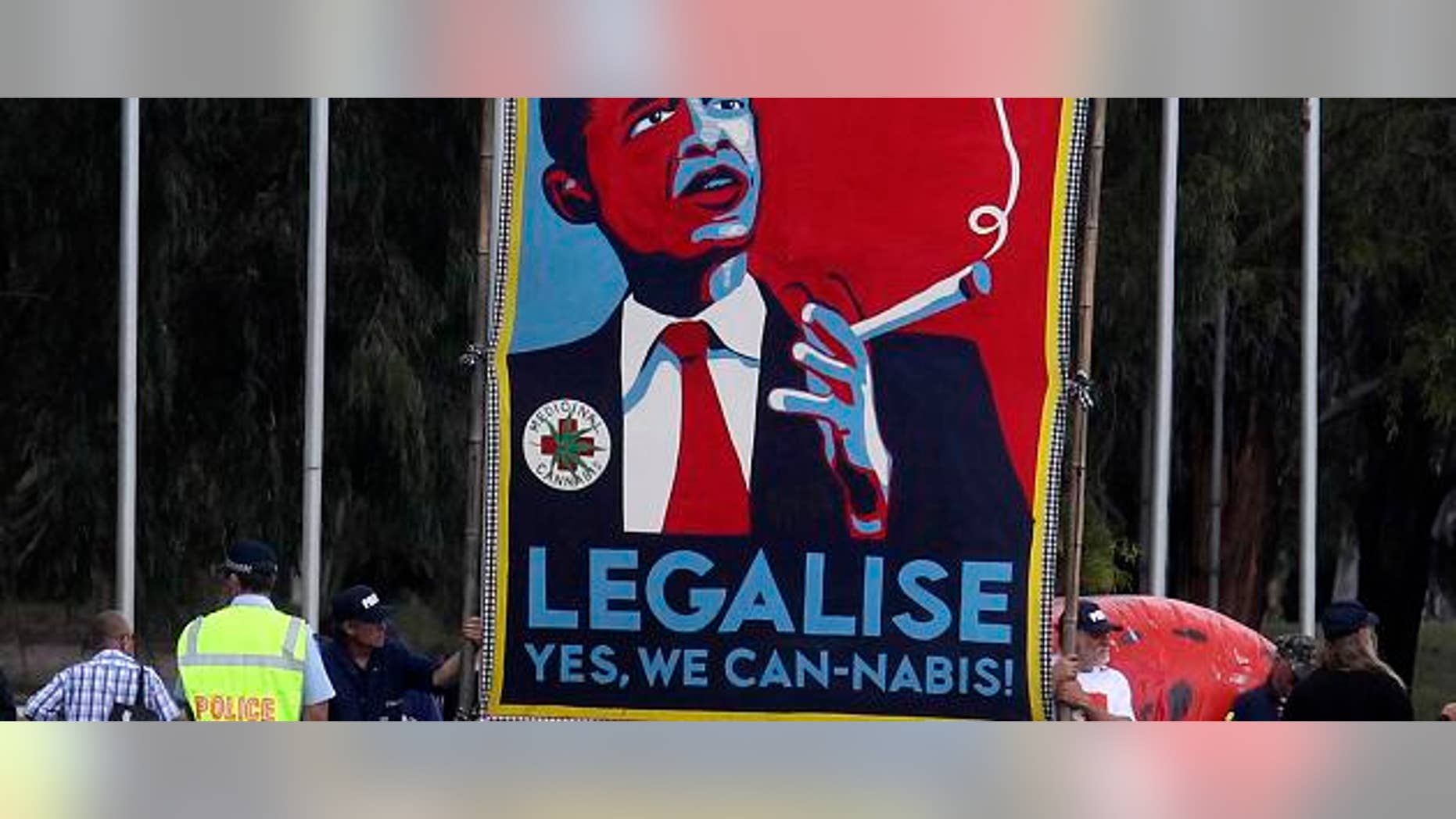 Protesters hold giant sign to legalize marijuana before U.S. President Barack Obama arrives to participate in an official arrival ceremony at Parliment House in Canberra, Australia, November 16, 2011. REUTERS/Larry Downing (AUSTRALIA - Tags: POLITICS) - RTR2U2RV