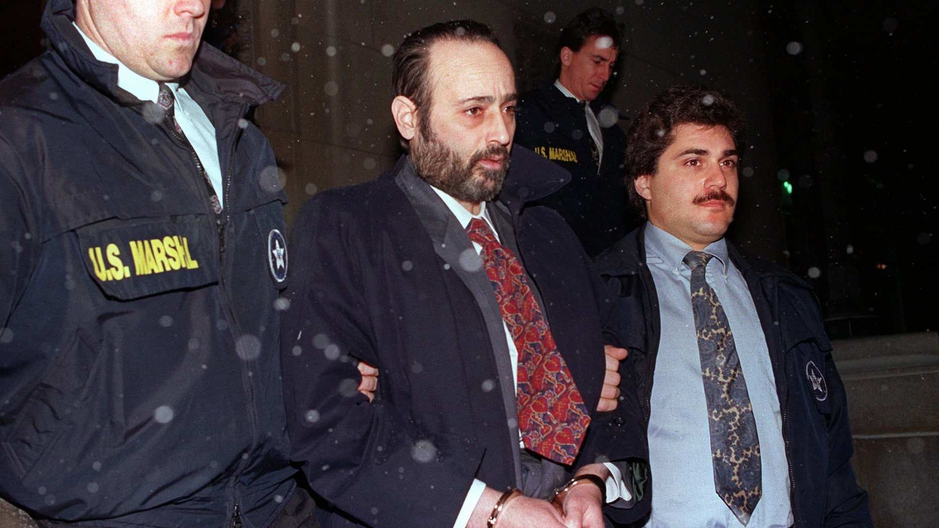 In this Jan. 11, 1993 file photo, "Crazy" Eddie Antar, center, founder of the Crazy Eddie electronics store chain, is led in handcuffs after being extradited from Israel.