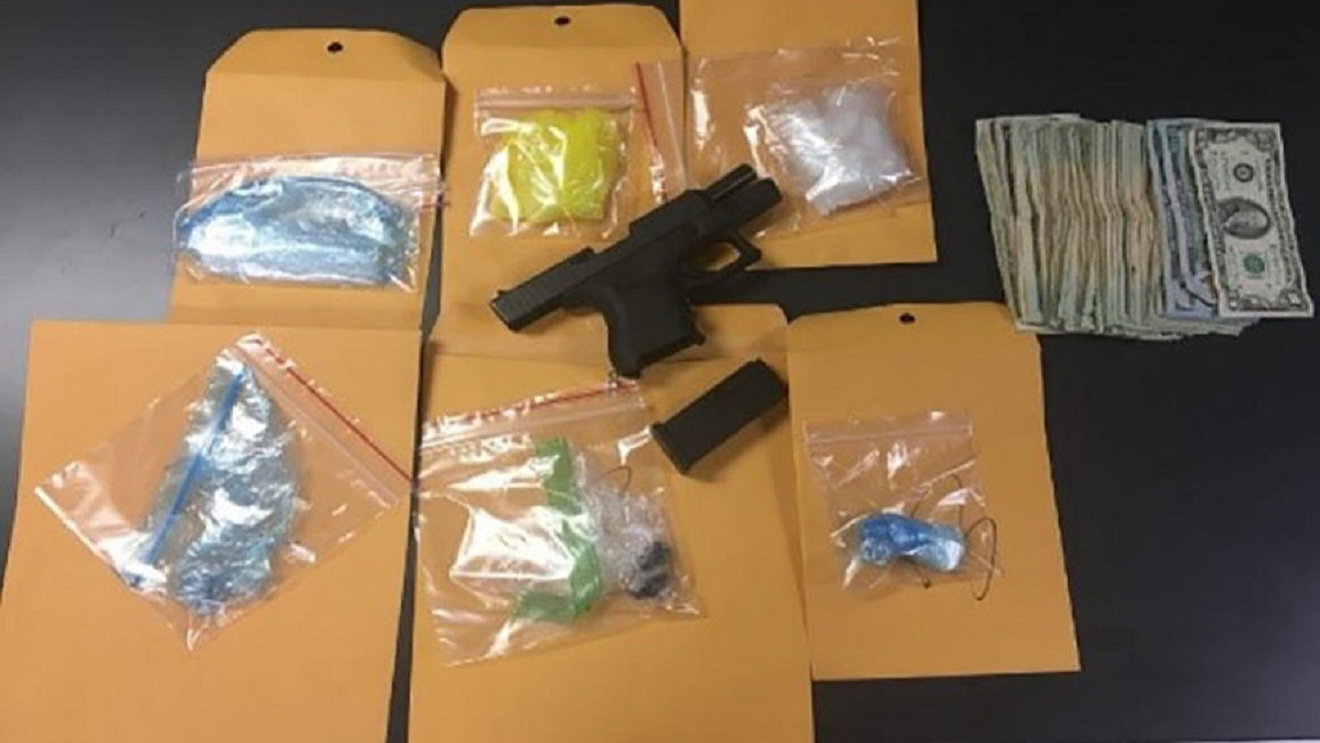 Weapons, cash and other items seized from so-called "Mexican Mafia" suspects in "Operation Scarecrow" are seen in Orange County, Calif., May 2, 2018.