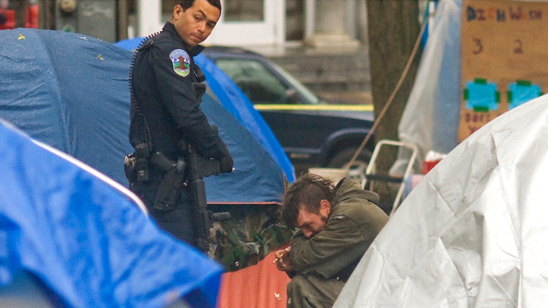 Nov. 10, 2011: A Burlington, Vt., police officer questions a witness at the Occupy Burlington encampment in City Hall Park after a man suffered a gun shot wound.