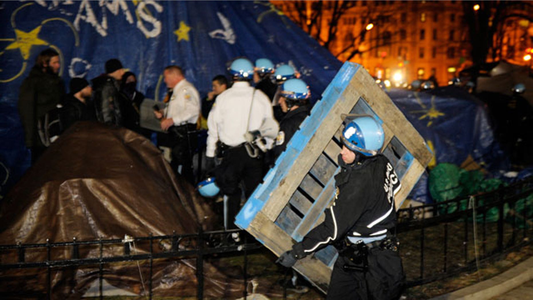 Feb. 4, 2012: A U.S. Park Police officer removes a wooden structure from an Occupy DC protestor's tent at McPherson Square in Washington.