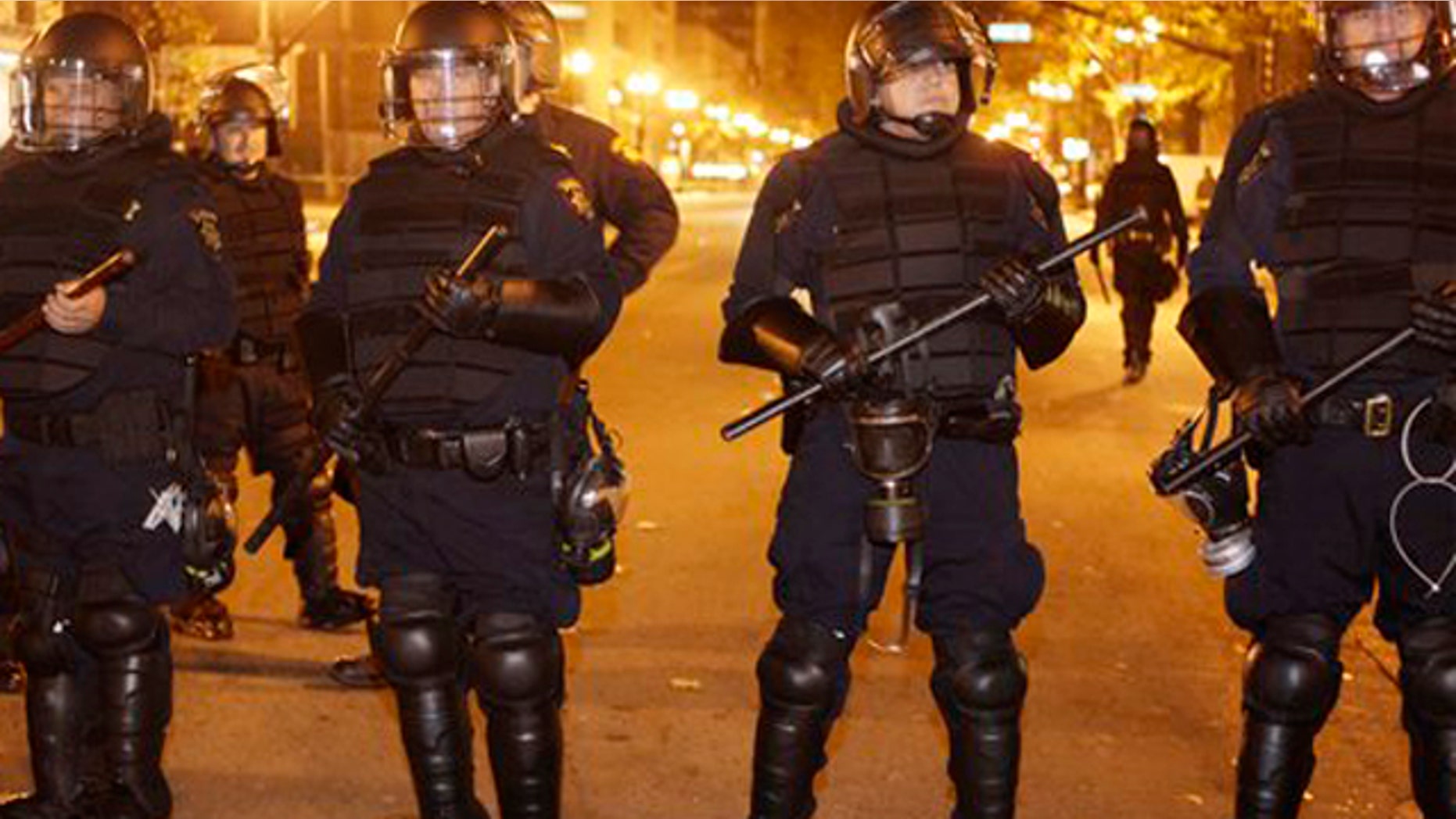 A line of police stand staged at an Occupy Oakland encampment in Oakland, Calif., early Monday, Nov. 14, 2011.