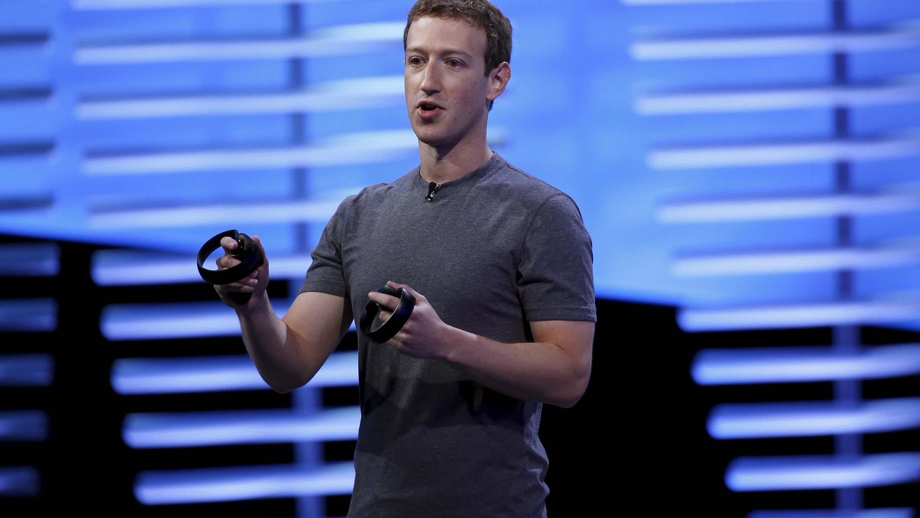 File photo - Facebook CEO Mark Zuckerberg holds a pair of the touch controllers for the Oculus Rift virtual reality headsets on stage during the Facebook F8 conference in San Francisco, California April 12, 2016. (REUTERS/Stephen Lam)
