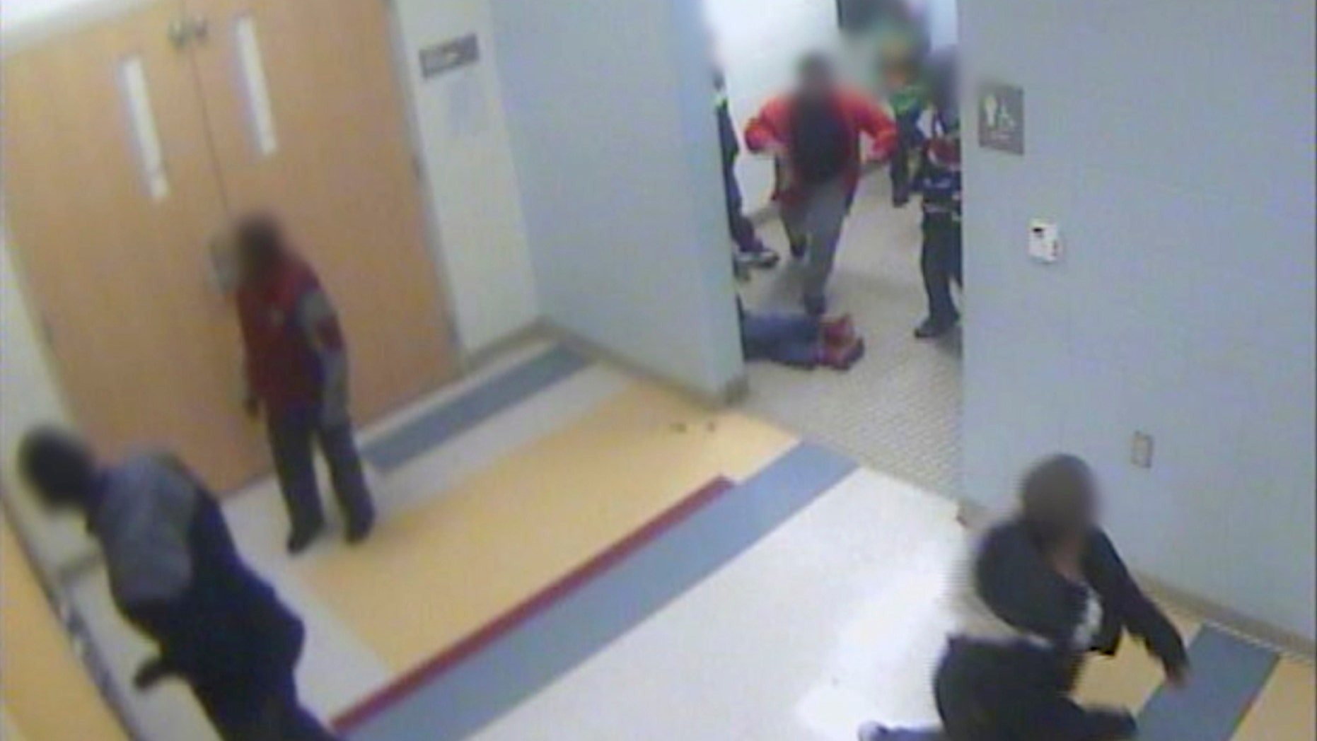 In this still image from a Jan. 24, 2017, surveillance video provided by Cincinnati Public Schools, the legs and feet of 8-year-old Gabriel Taye can be seen as he lies on the floor of a boys' bathroom after being knocked unconscious by another boy at Carson Elementary School.