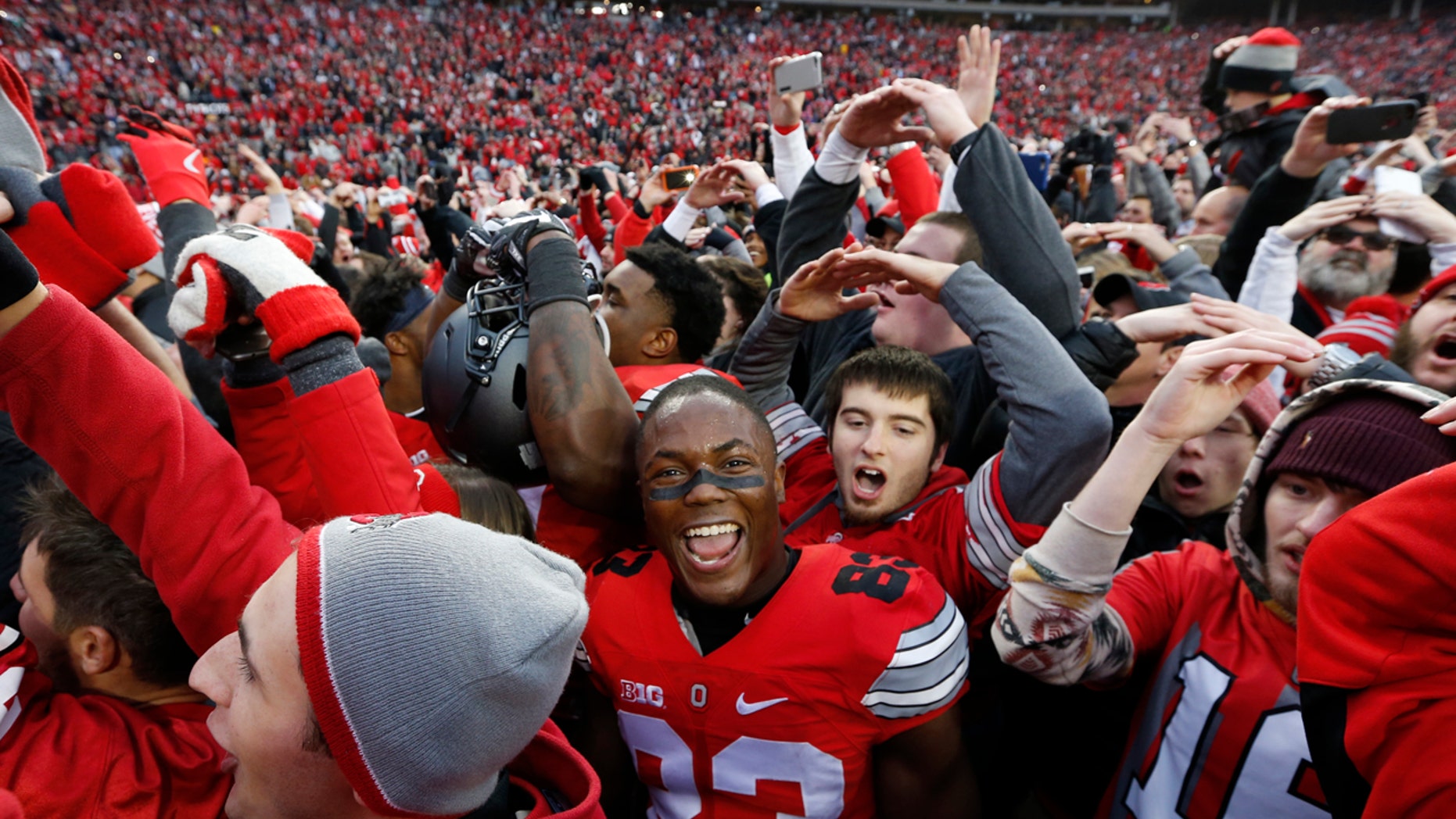 FILE - In this Saturday, Nov. 26, 2016, file photo, Ohio State players and fans celebrate their win over Michigan in an NCAA college football game in Columbus, Ohio.