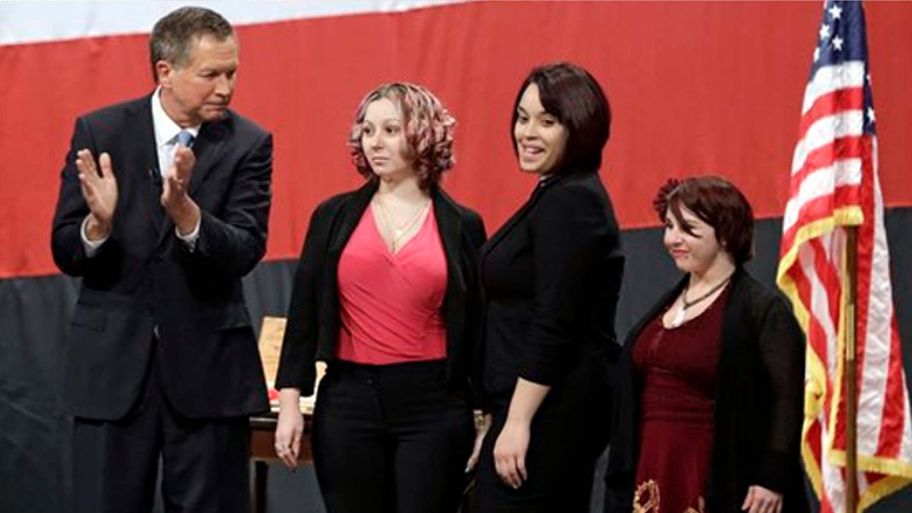 Feb. 24, 2014: Ohio Gov. John Kasich, from left, introduces Amanda Berry, Gina DeJesus and Michelle Knight during his State of the State address at the Performing Arts Center in Medina, Ohio.