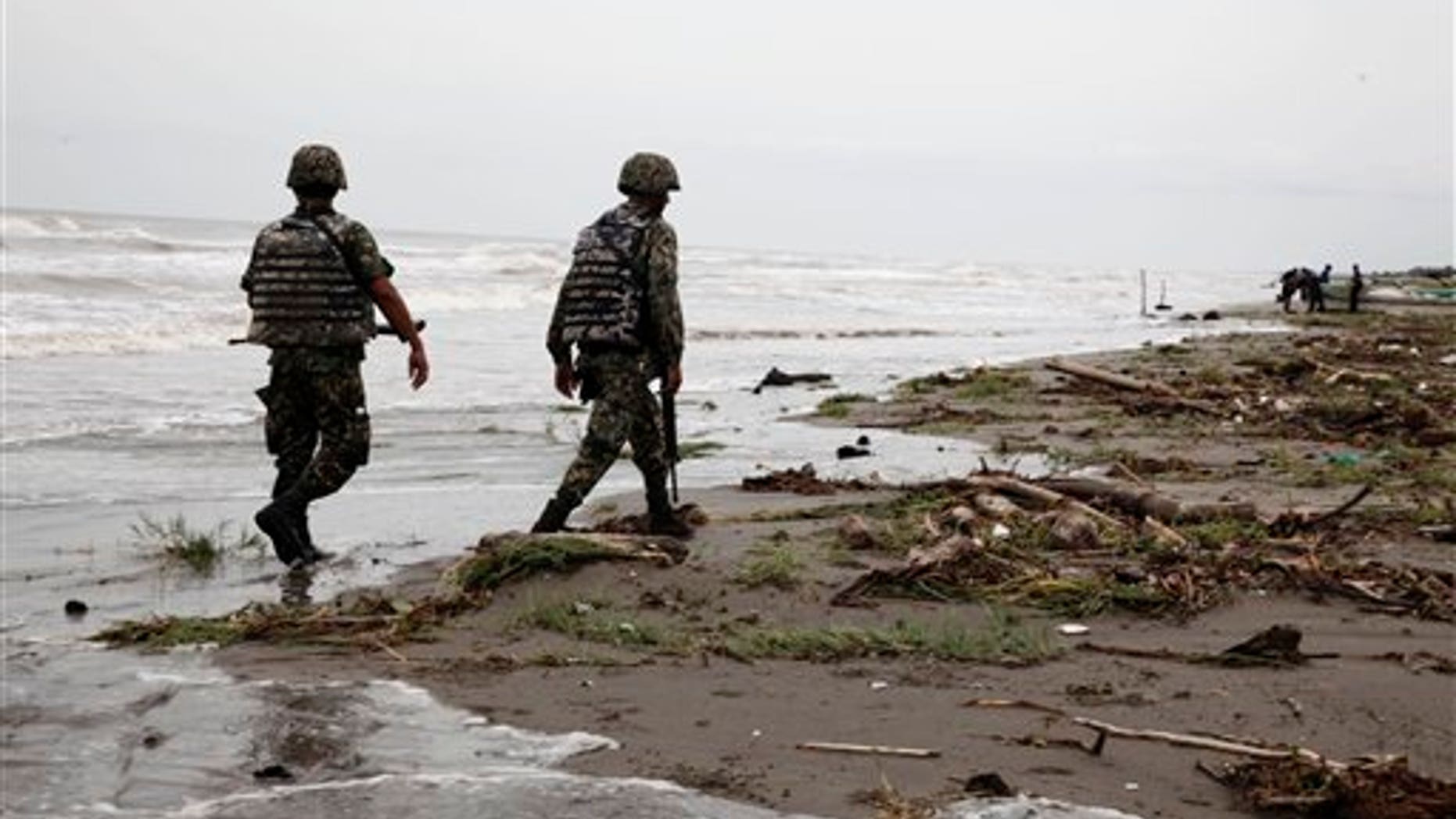 Sept. 10: Navy officers walk along El Bosque beach, in Mexico's Tabasco state. Mexico's state oil company and a Texas-based company searched for 10 missing oil workers on Friday, including four Americans, who evacuated from a research vessel in the Gulf of Mexico ahead of Tropical Storm Nate.