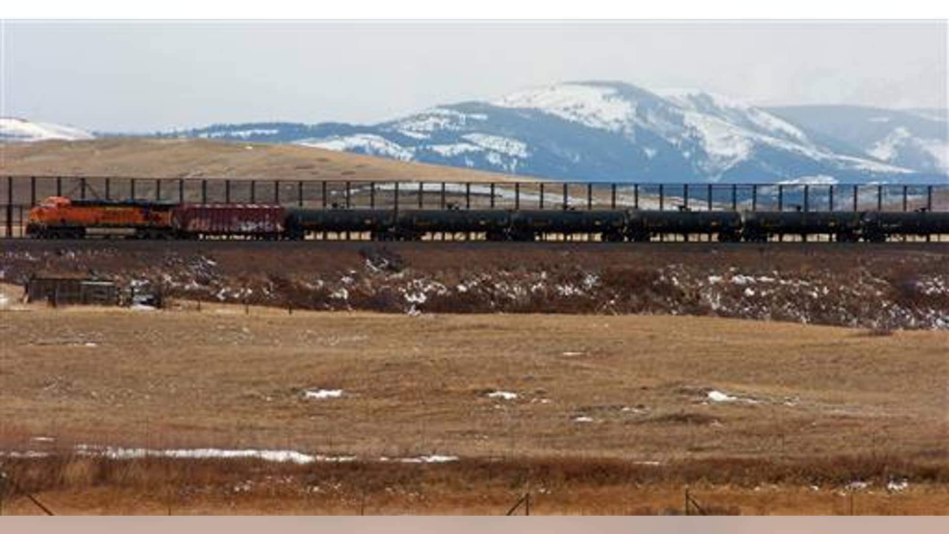 In this Nov. 7, 2013, photo, a train hauls oil into Glacier National Park near the Badger-Two Medicine National Forest in northwest Montana. Companies proposing to build the nation's largest oil-by-rail marine terminal in southwest Washington State and their foes will argue their cases before a state energy panel in Vancouver, Wash., on Monday, June 27, 2016. (AP Photo)