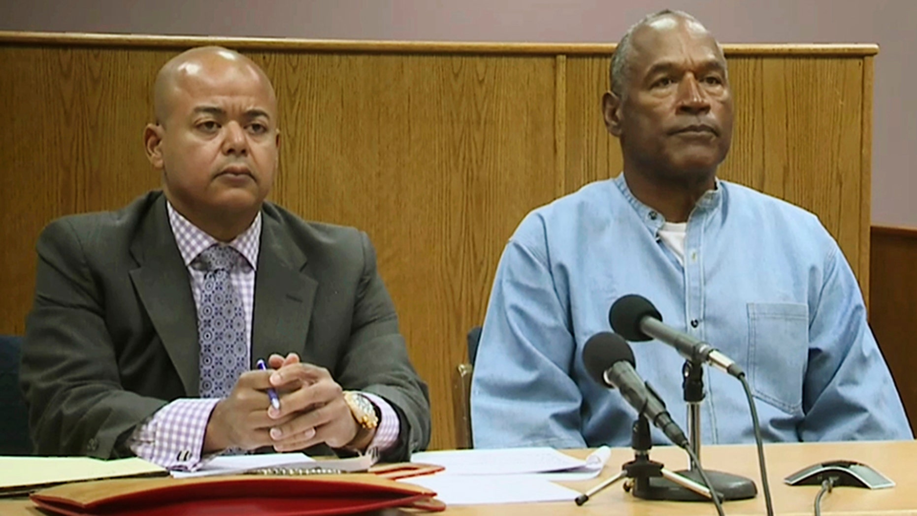 Former NFL football star O.J. Simpson appears with his attorney, Malcolm LaVergne, left, via video for his parole hearing at the Lovelock Correctional Center in Lovelock, Nev.