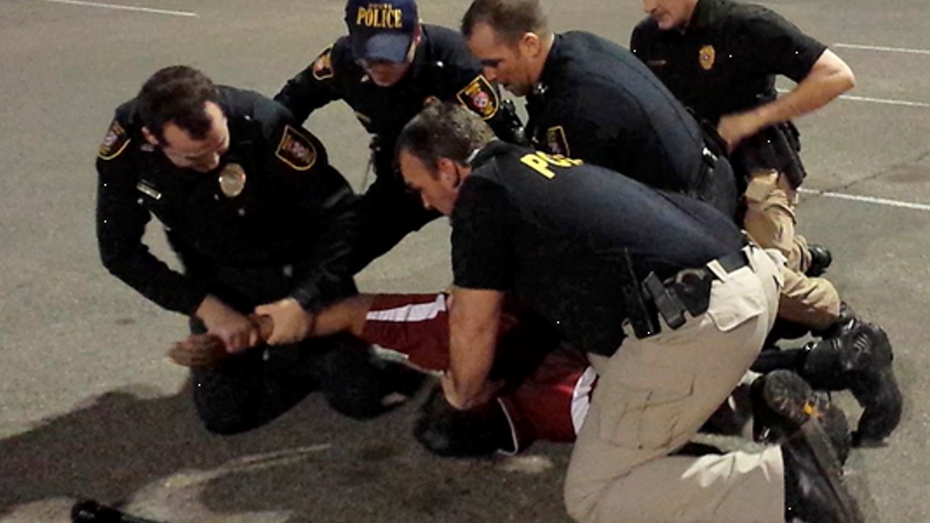 Police restraining Luis Rodriguez.