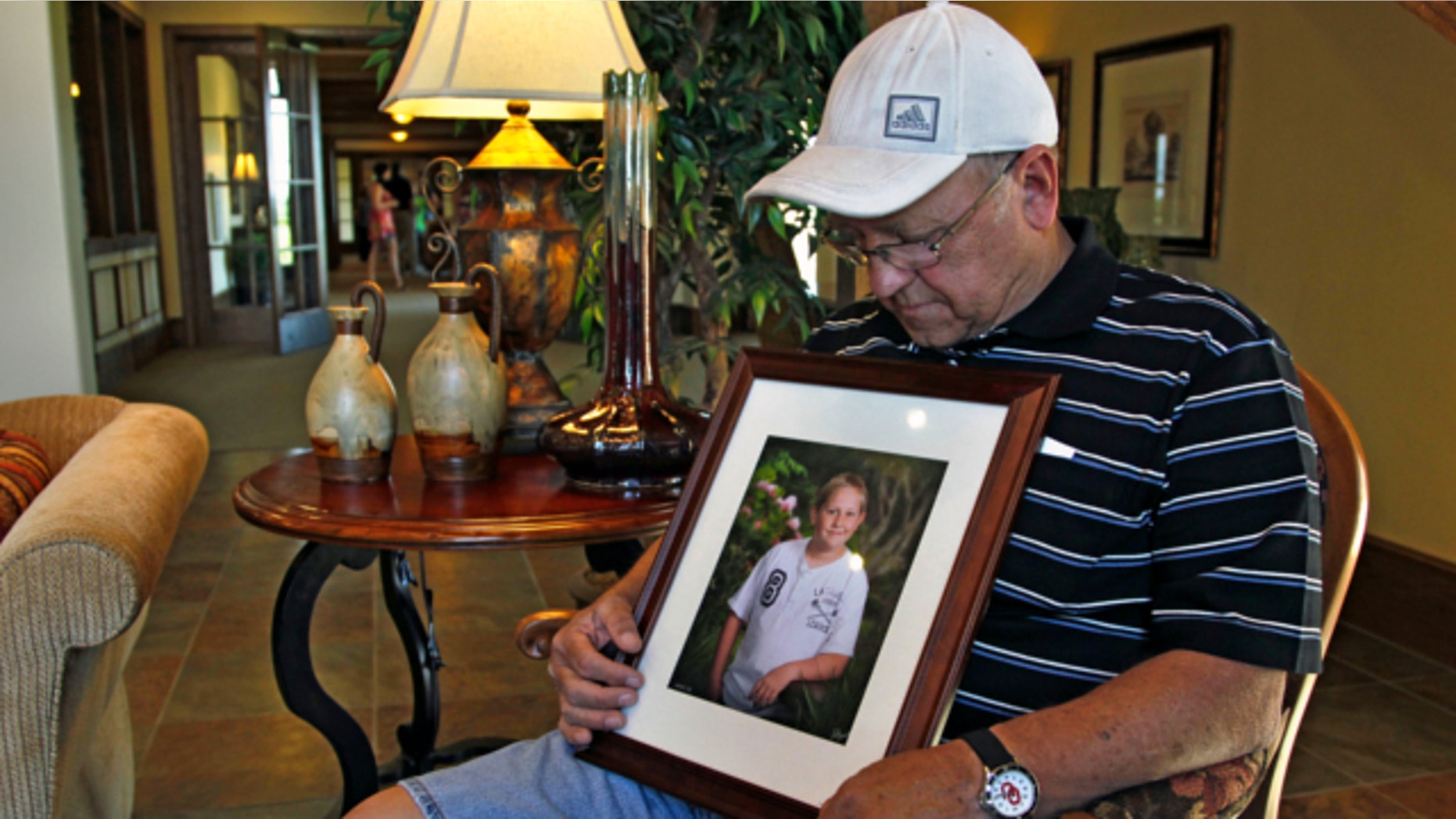 May 22, 2013: Marvin Dixon, the grandfather of 8-year-old tornado victim Kyle Davis, glances down at a photo of his grandson while sitting for a portrait in the lobby of a funeral home where his grandson awaits burial, in Oklahoma City.