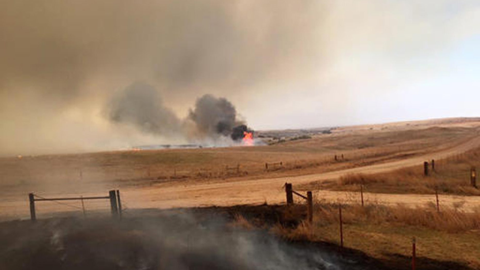 This April 5, 2016 photo provided by Landon Cates, volunteer firefighters from the Dewey County Task Force work a blaze southwest of Freedom, Okla. Oklahoma Forestry Services Director George Geissler says arcing power lines are to blame for the blaze in northwest Oklahoma, located about 170 miles northwest of Oklahoma City. (Landon Cates/Leedy Fire Department via AP)