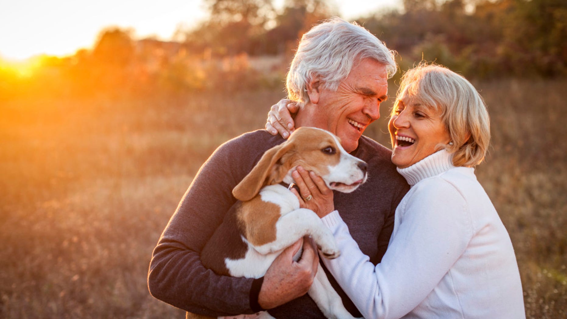 An older boomer couple enjoy time with their dog.