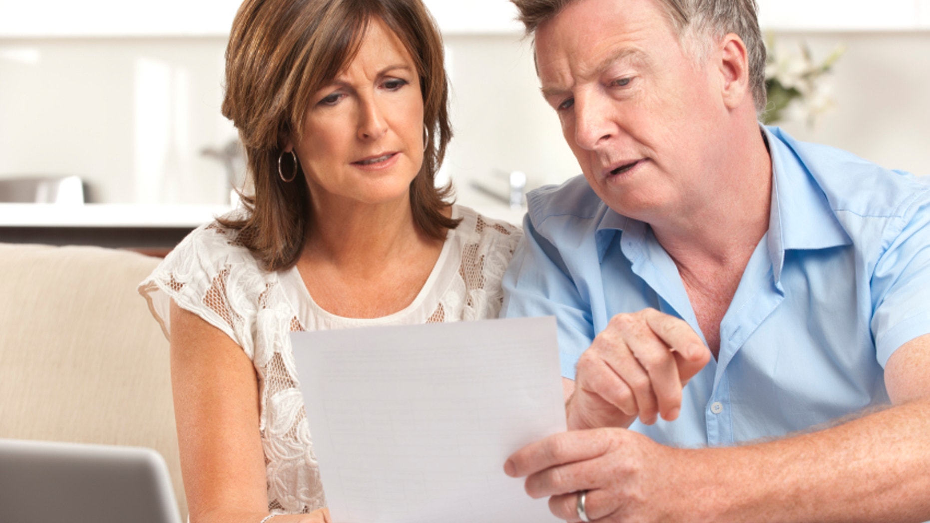 Mature couple worrying about finances at home