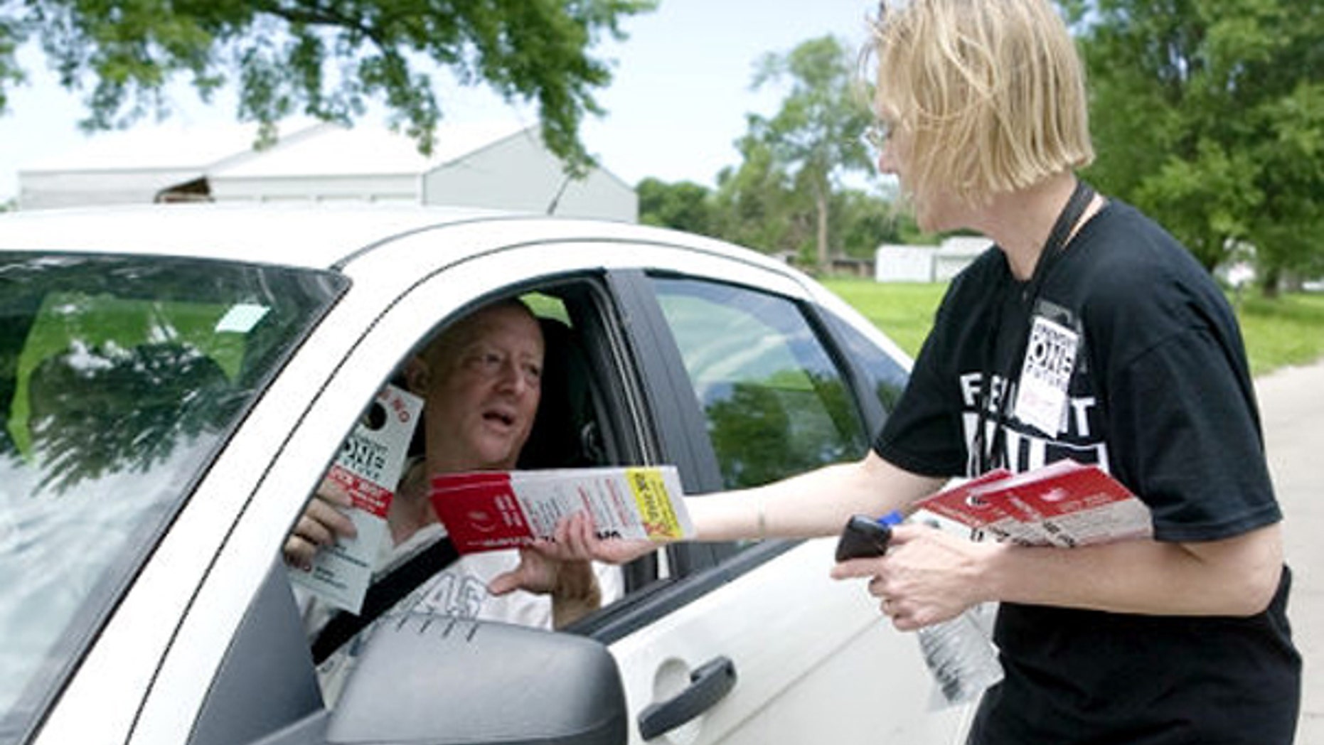 Activist Kristin Olstrom hands out material in opposition to a proposed law in Fremont, Neb., that would impose new restrictions on illegal immigrants. (AP Photo)