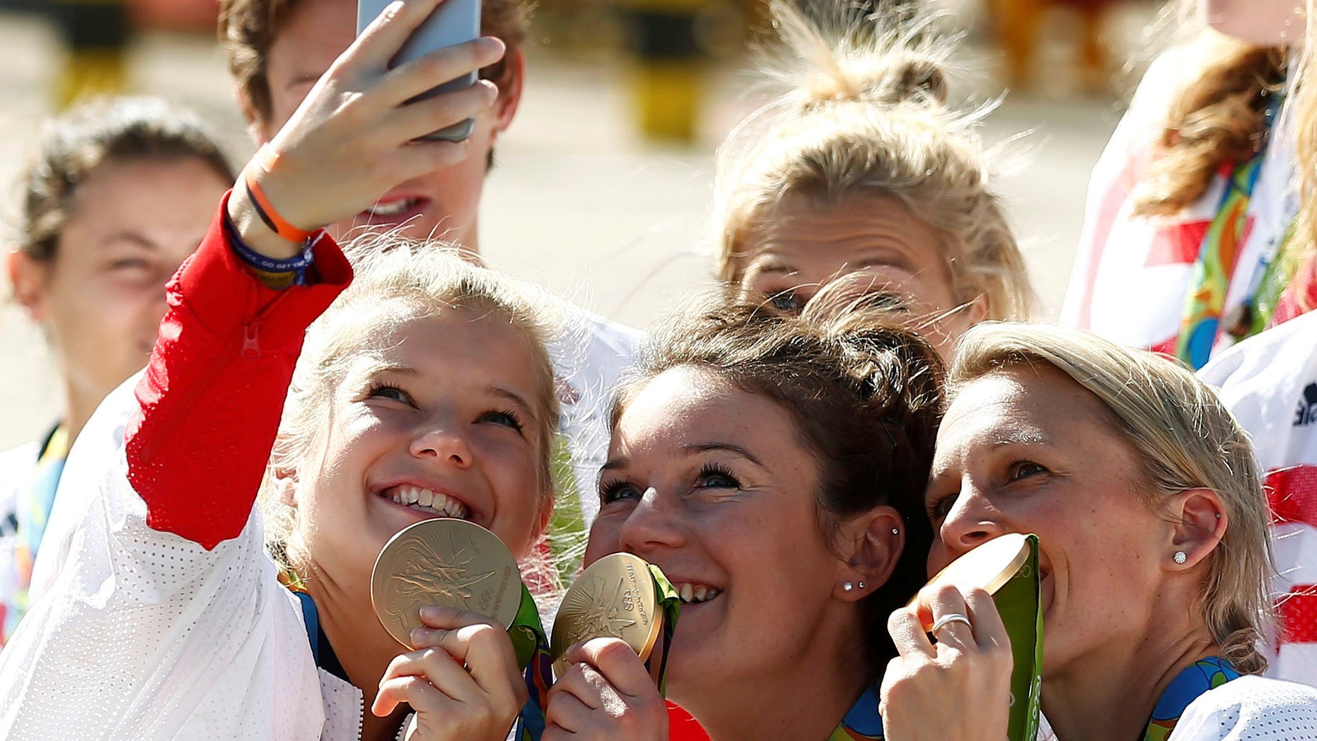 Team GB athletes pose with their medals for selfies as they return home from the 2016 Rio Olympics, at Heathrow Airport in London, Britain August 23, 2016. (REUTERS/Peter Nicholls)