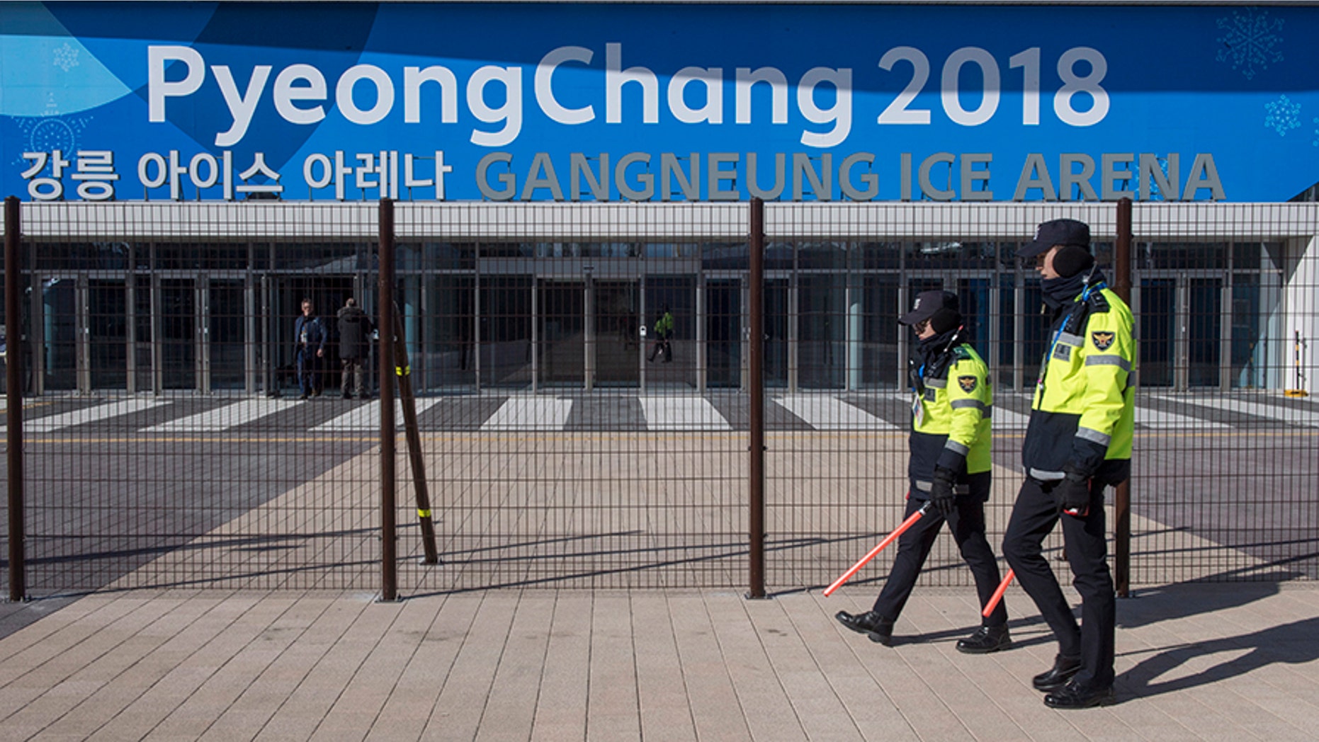 Police officers walk the perimeter of the Gangneung Ice Arena where the figure skating and short track speed skating will be held during the Pyeungchang Winter Olympics Monday, Feb. 5, 2018 in Gangneung, South Korea. (Paul Chiasson/The Canadian Press via AP)