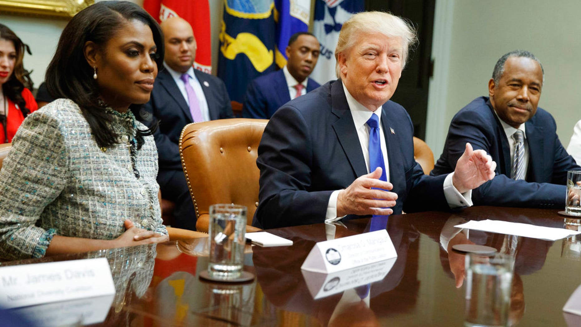 FILE - In this Feb. 1, 2017, file photo, President Donald Trump, center, is flanked by White House staffer Omarosa Manigault Newman, left, and then-Housing and Urban Development Secretary-designate Ben Carson as he speaks during a meeting on African American History Month in the Roosevelt Room of the White House in Washington. Manigault Newman, who was fired in December, released a new book "Unhinged," about her time in the White House. (AP Photo/Evan Vucci, File)