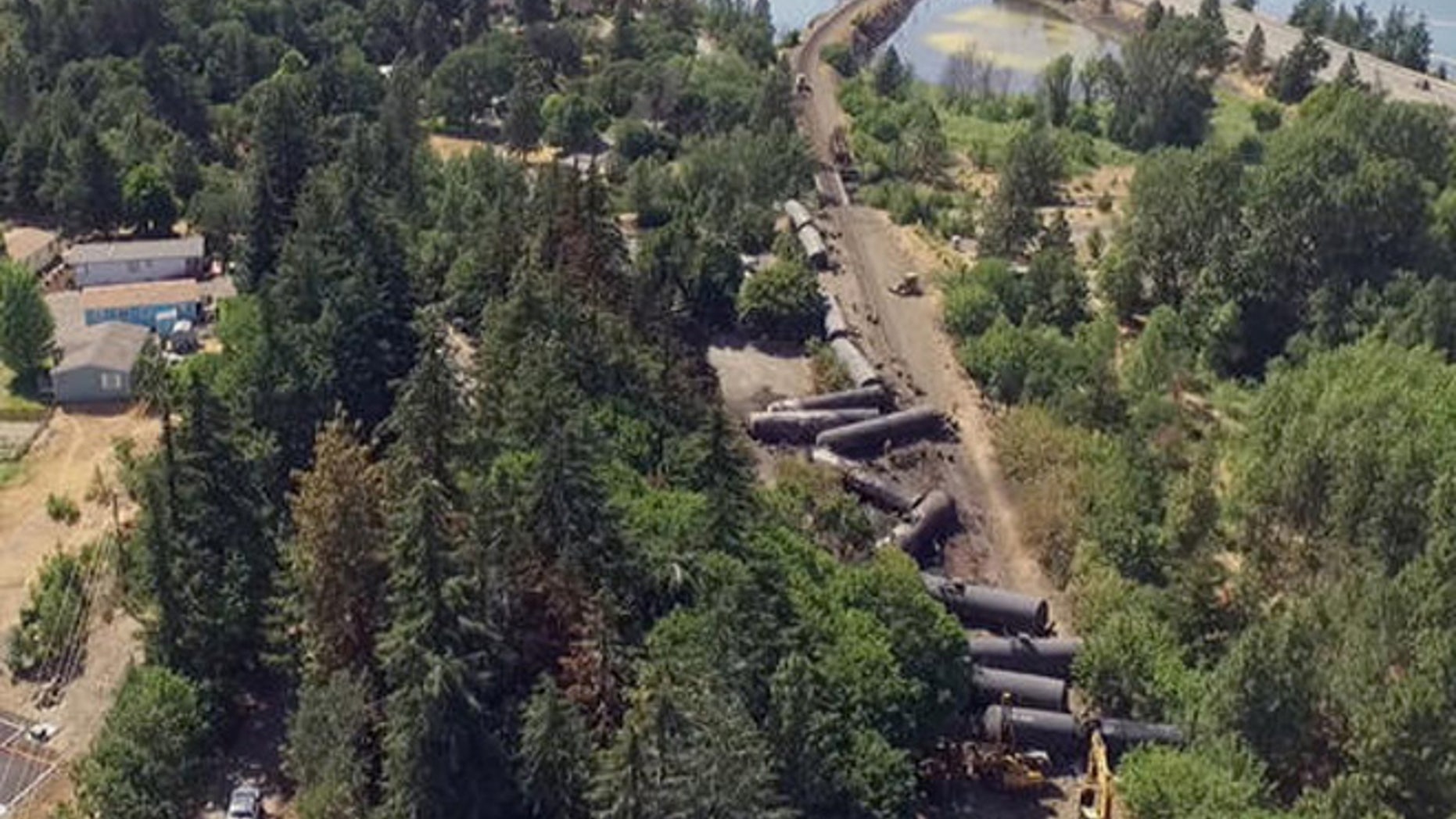 This video image taken from a drone shows an aerial view of crumpled oil tankers lying beside the railroad tracks after a fiery train derailment on June 3 prompted evacuations from the tiny Columbia River Gorge town about 70 miles east of Portland, on Monday, June 6, 2016, in Mosier, Ore.