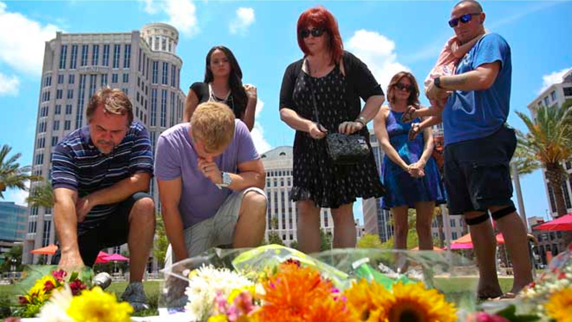 Mourners at a makeshift memorial for the victims of the Pulse nightclub shooting outside of the Dr. Phillips Performing Arts Center on Monday , June 13, 2016.