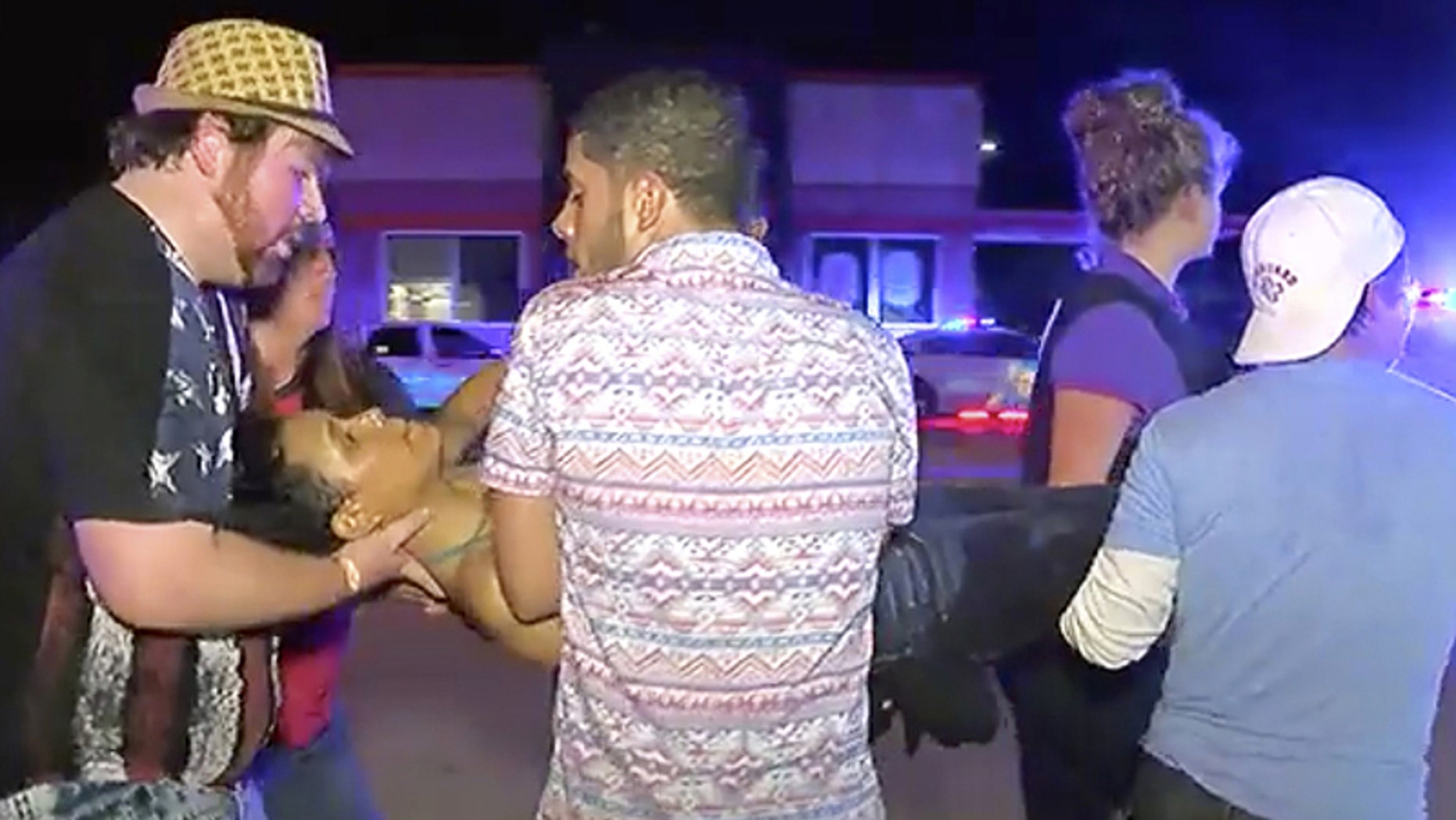 An injured person is escorted out of the Pulse nightclub after a shooting rampage, Sunday morning June 12, 2016, in Orlando, Fla.