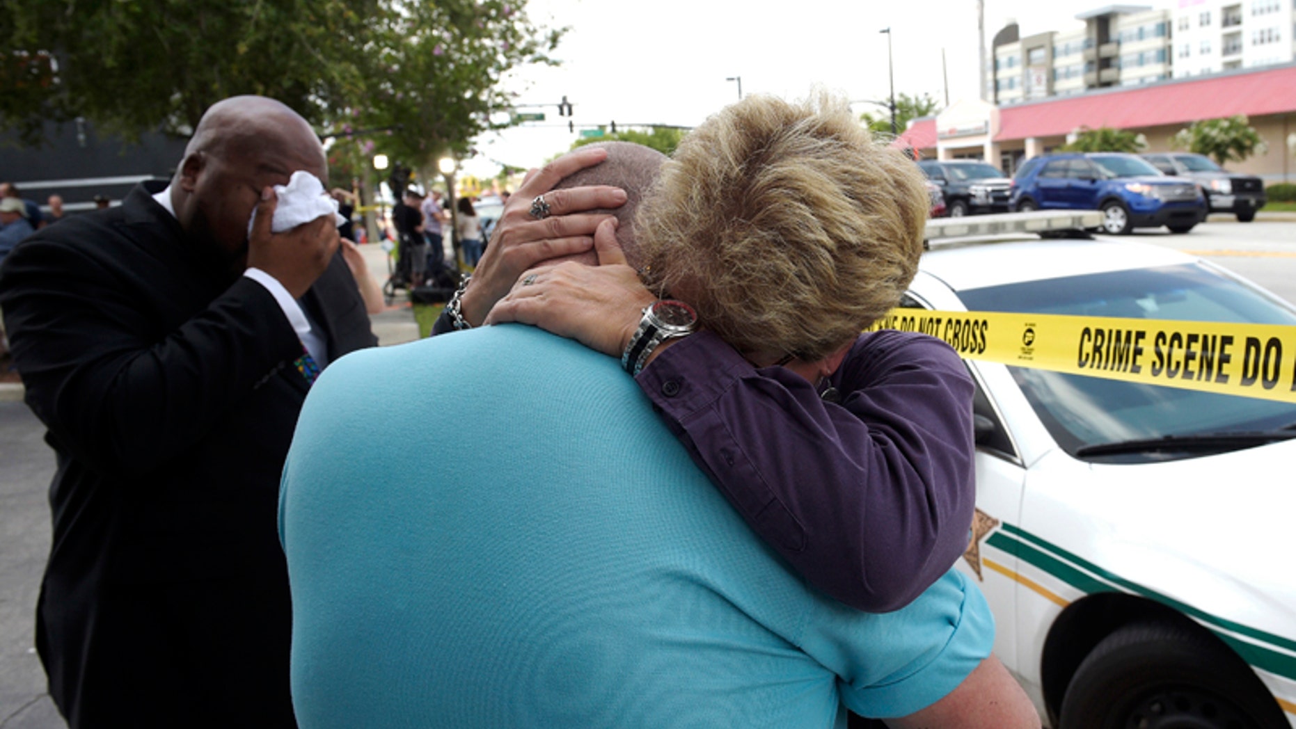 Terry DeCarlo, executive director of the LGBT Center of Central Florida, center, is comforted by Orlando City Commissioner Patty Sheehan, right, after a shooting involving multiple fatalities at a nightclub in Orlando, Fla., Sunday, June 12, 2016. (AP Photo/Phelan M. Ebenhack)