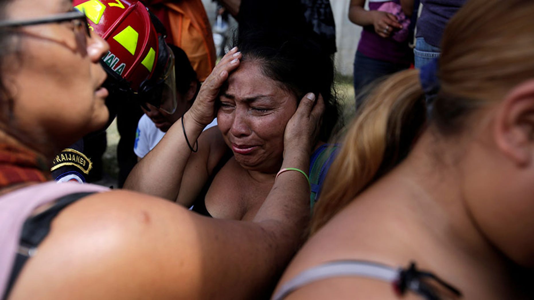 Family members wait for news of their loved ones after a fire broke at the Virgen de Asuncion home in San Jose Pinula, on the outskirts of Guatemala City, Guatemala March 8, 2017.