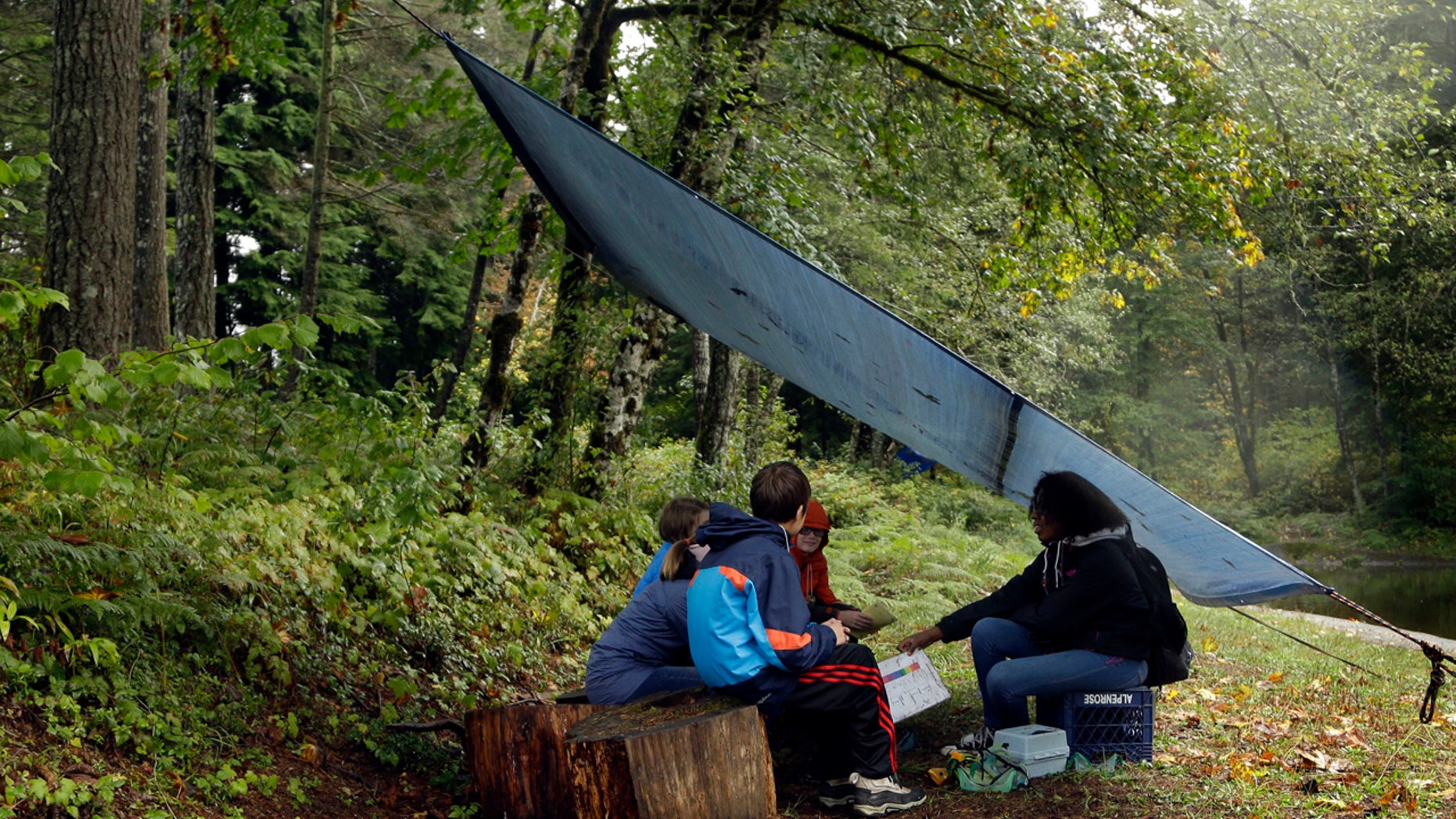 In this Oct. 6, 2016 photo, Outdoors School students gather for a lesson under a canopy in the forest at Camp Howard in Mount Hood National Forest near Corbett, Ore.