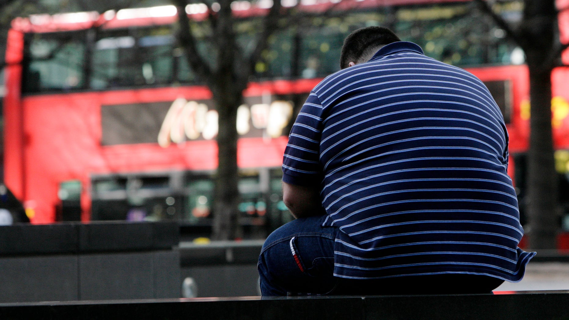 A man sits on a wall in the Canary Wharf financial district of London, April 1, 2009. (REUTERS/Simon Newman)