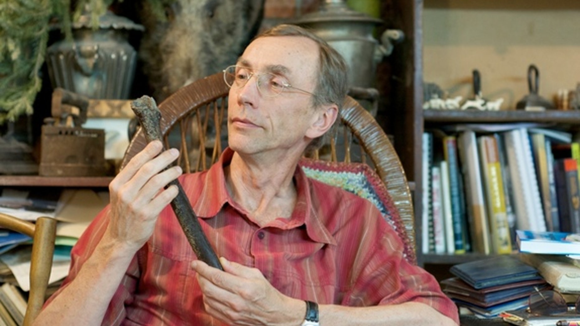 Study researcher Svante Pääbo examines a 45,000-year-old femur from a Siberian man that is helping scientists pinpoint when Neanderthals and modern humans interbred.