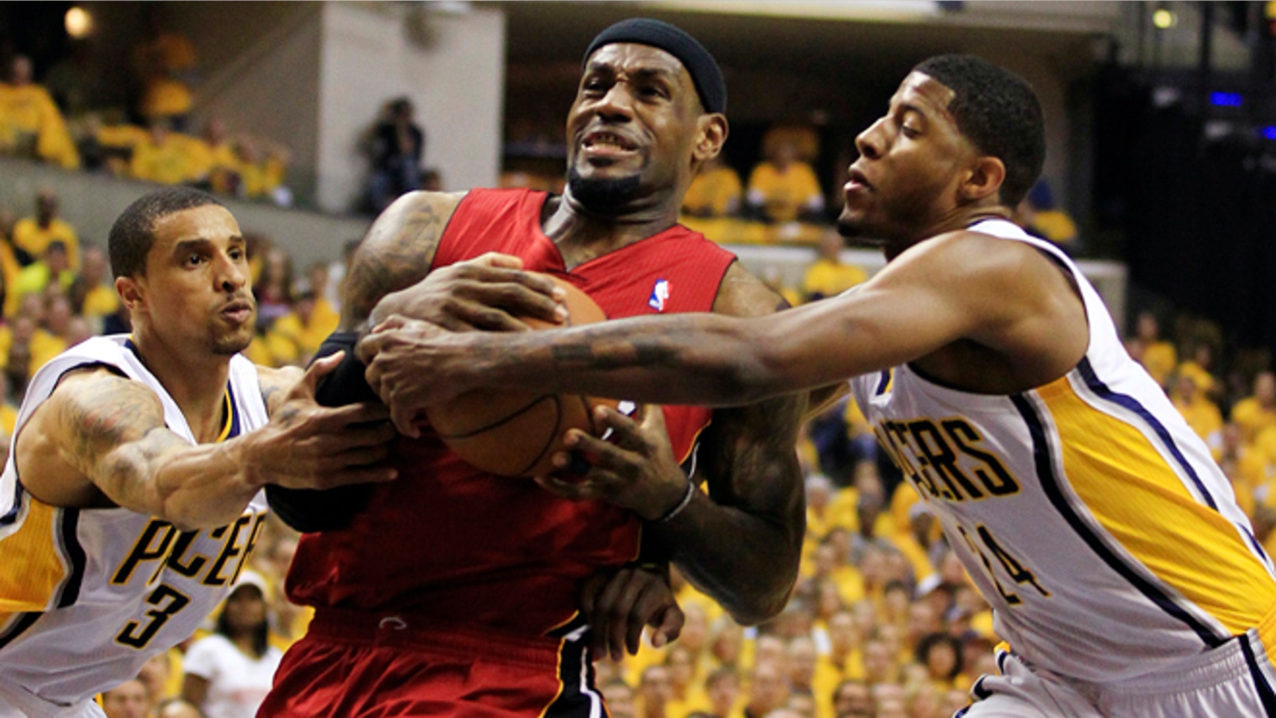 Miami Heat's LeBron James, center, goes to the basket against Indiana Pacers' George Hill (3) and Paul George, right, during the first half of Game 3 of their NBA basketball Eastern Conference semifinal playoff series, Thursday, May 17, 2012, in Indianapolis. (AP Photo/Darron Cummings)