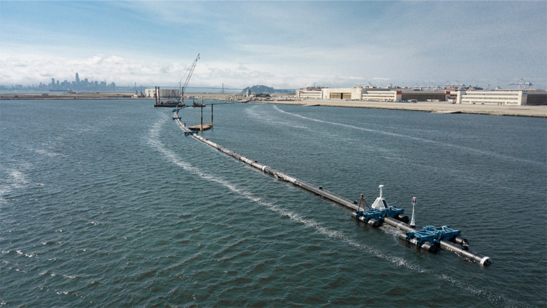 In this Monday, Aug. 27, 2018 photo provided by The Ocean Cleanup, a long floating boom that will be used to corral plastic litter in the Pacific Ocean is assembled in Alameda, Calif. Engineers will deploy a trash collection device to corral plastic litter floating between California and Hawaii in an attempt to clean up the world's largest garbage patch. The 2,000-foot long floating boom will be towed Saturday, Sept. 8, 2018, from San Francisco to the Great Pacific Garbage Patch, an island of trash twice the size of Texas.