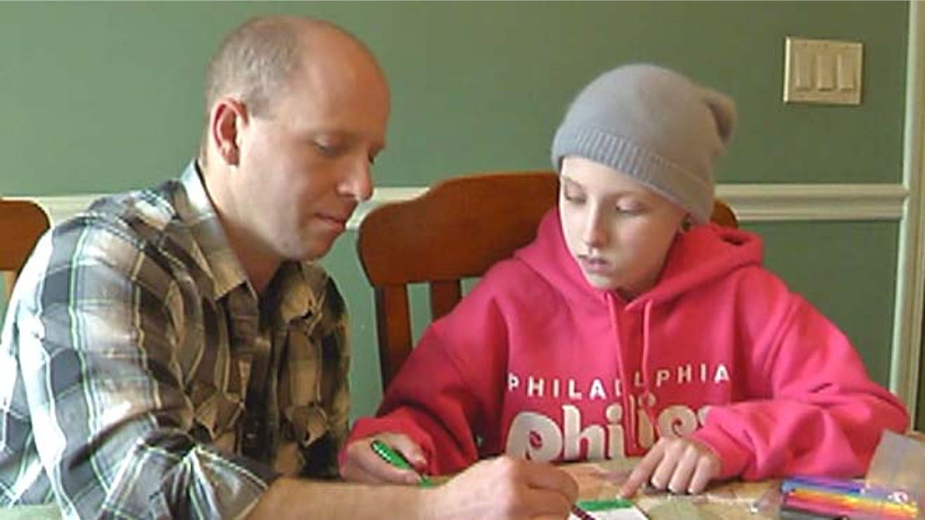Paige gets help from her father Shane on her schoolwork.