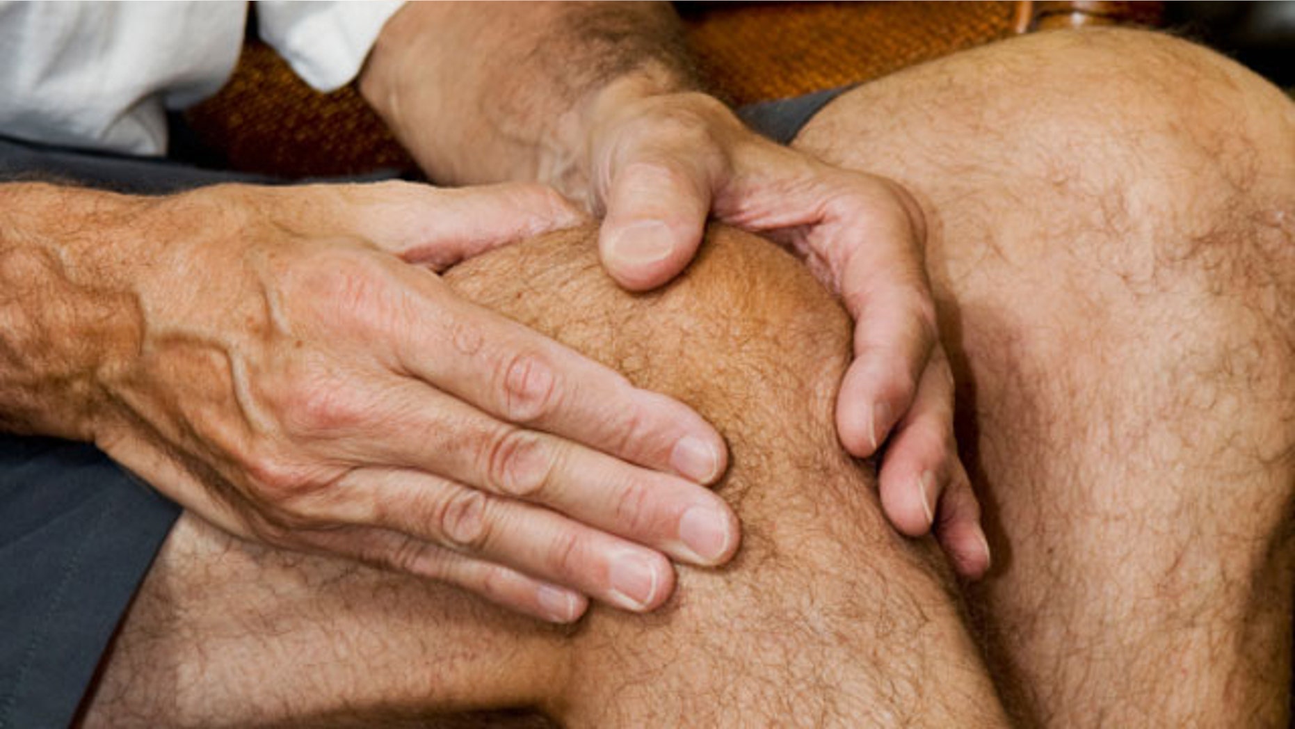 man massaging knee with apparent pain