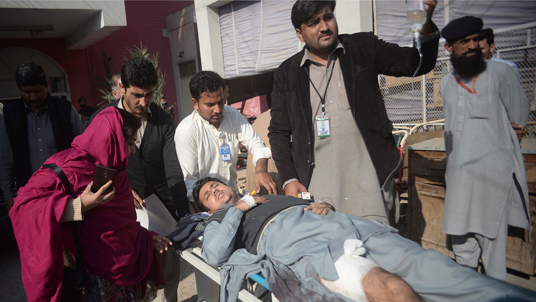 Dec. 1, 2017: Staff rush a man to a hospital after being injured during a crackdown operation against militants who stormed the agriculture institute in Peshawar, Pakistan.