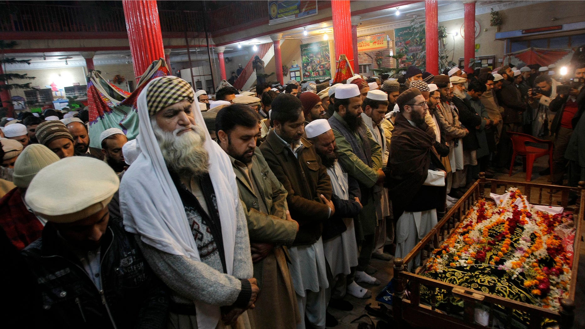 Dec. 16, 2014: Mourners and relatives of Pakistani teacher, Saeed Khan, a victim of a Taliban attack in a school, pray around his body, during his funeral procession in Peshawar, Pakistan.