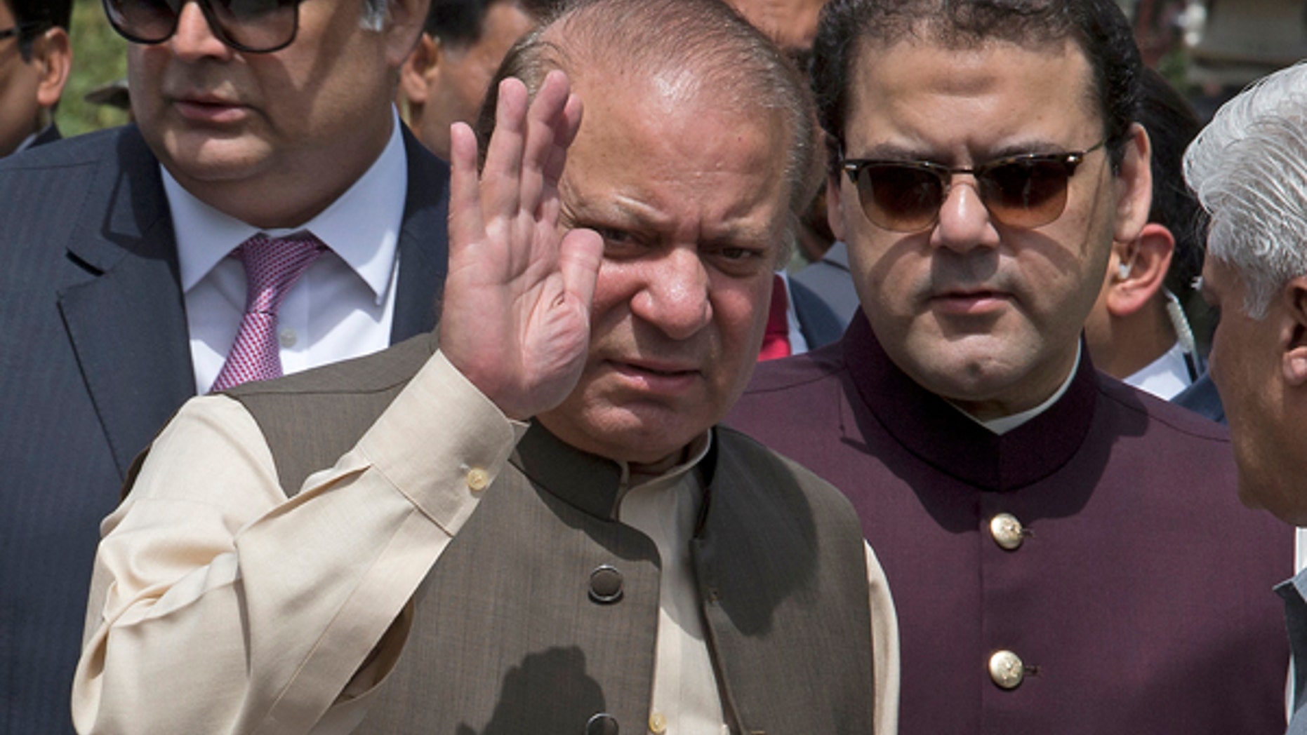 Pakistani Prime Minister Nawaz Sharif waves with his son Hussain Nawaz, right, outside the premises of the Joint Investigation Team, in Islamabad, Pakistan.