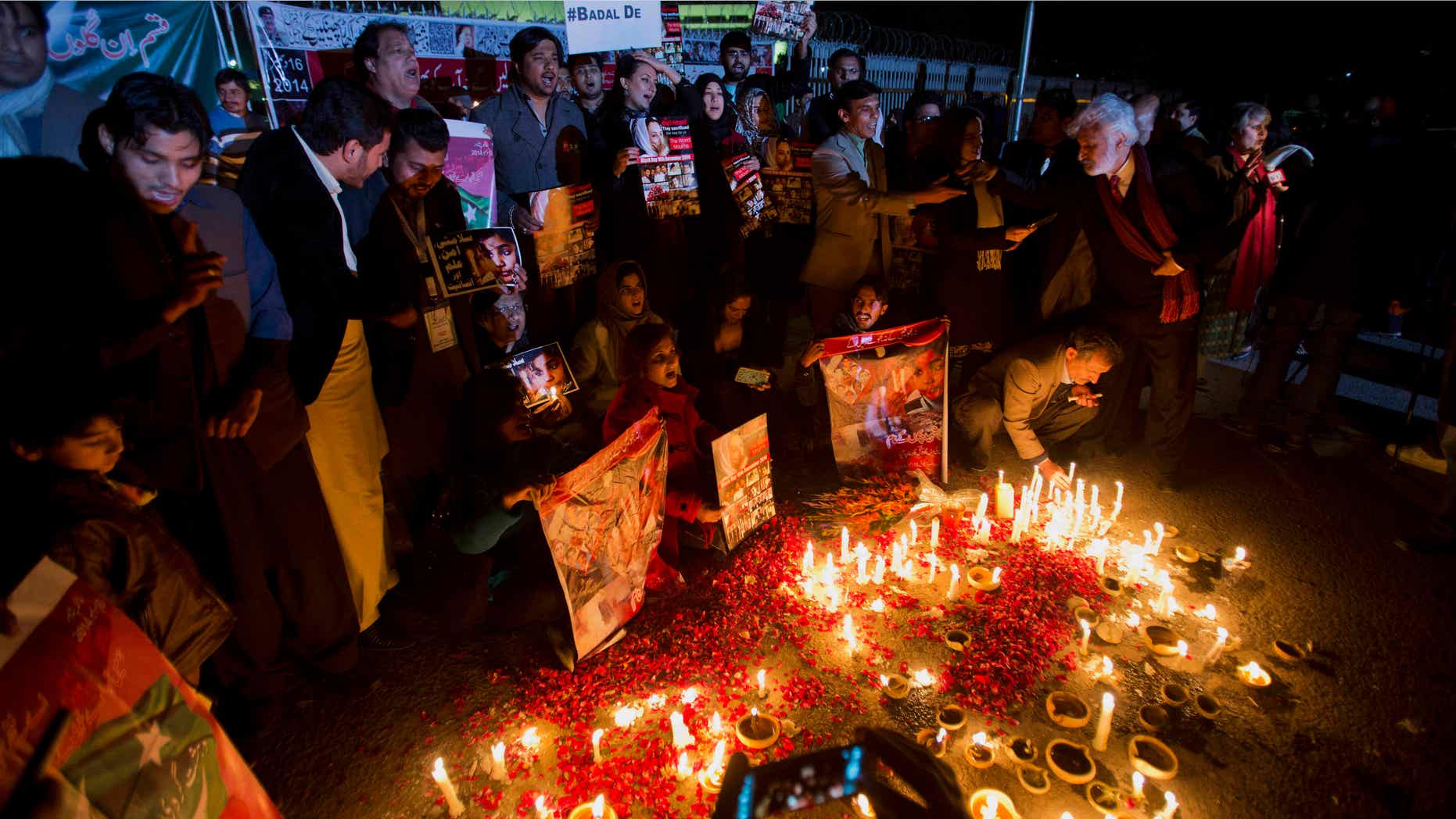 Jan. 16, 2015: Members of Pakistan's civil society groups light candles and shout anti-Taliban slogans to condemn the militant group's attack on a military-run school in Peshawar.