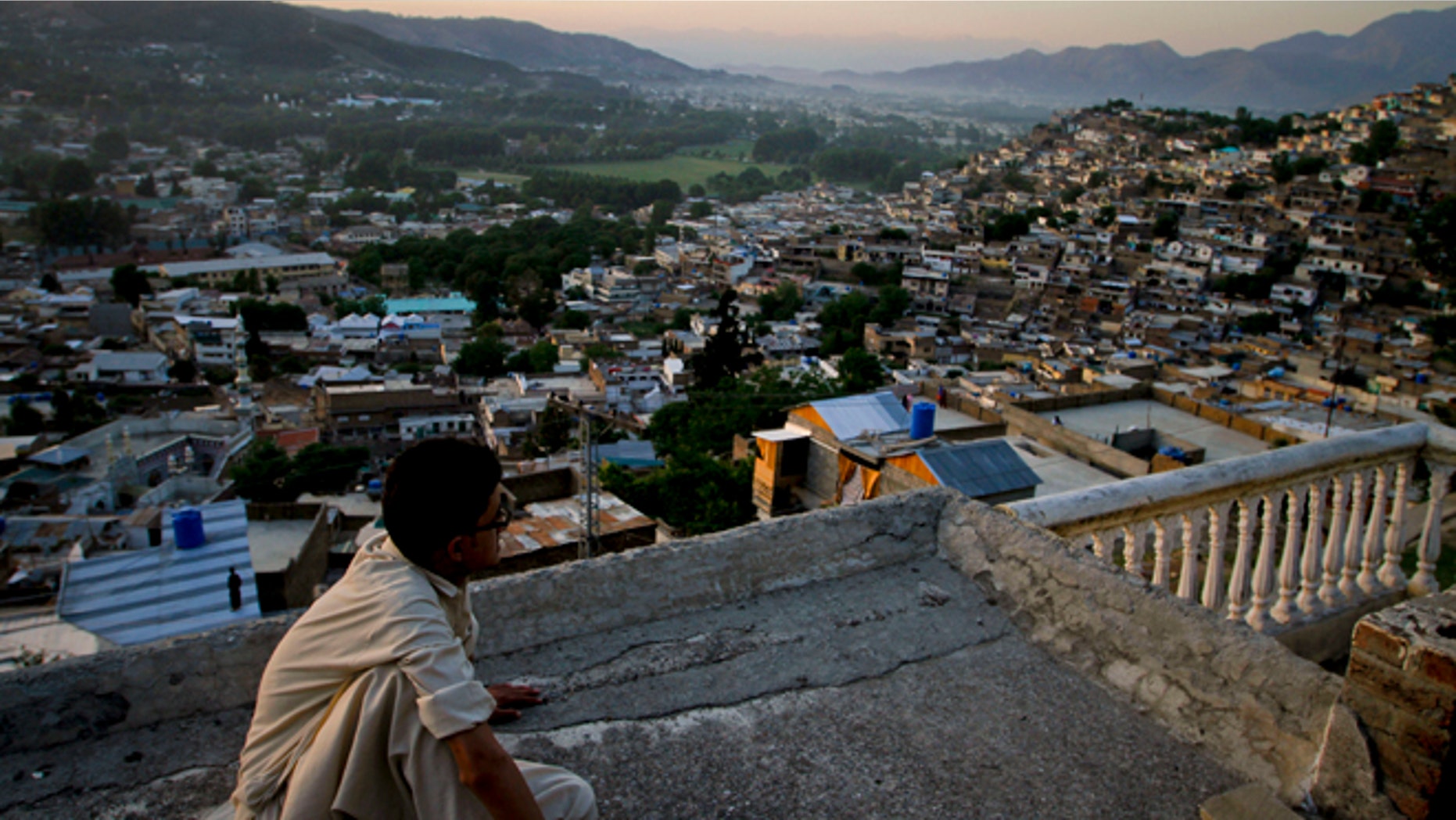 In this May 15, 2011 file photo, Ali Raza sits on the rooftop of his house as he views the city of Abbottabad, Pakistan. Pakistani officials say the government plans to build a recreation complex in the town.