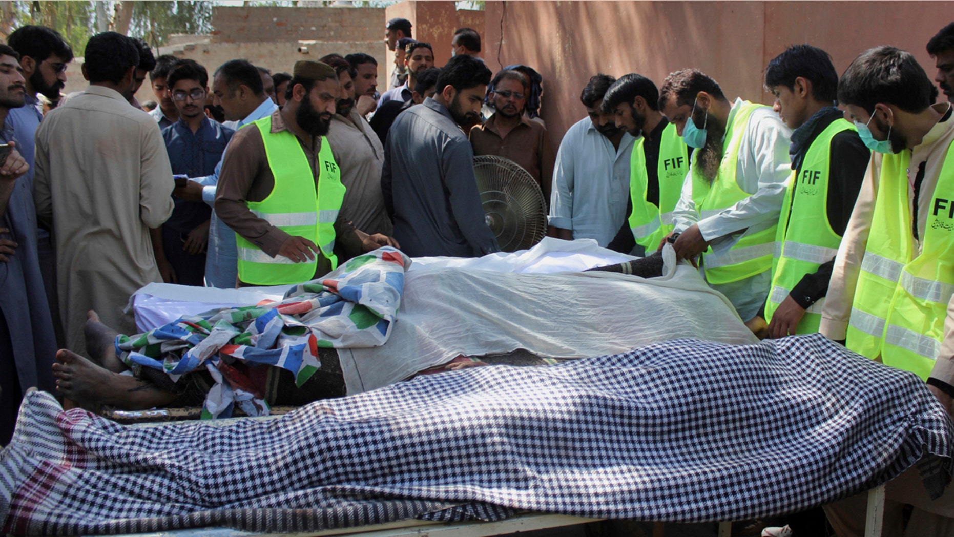 Pakistani volunteers and local residents gather around the bodies of people who were killed in a local shrine, outside the morgue of a hospital in Sarghodha, Pakistan, Sunday, April 2, 2017.