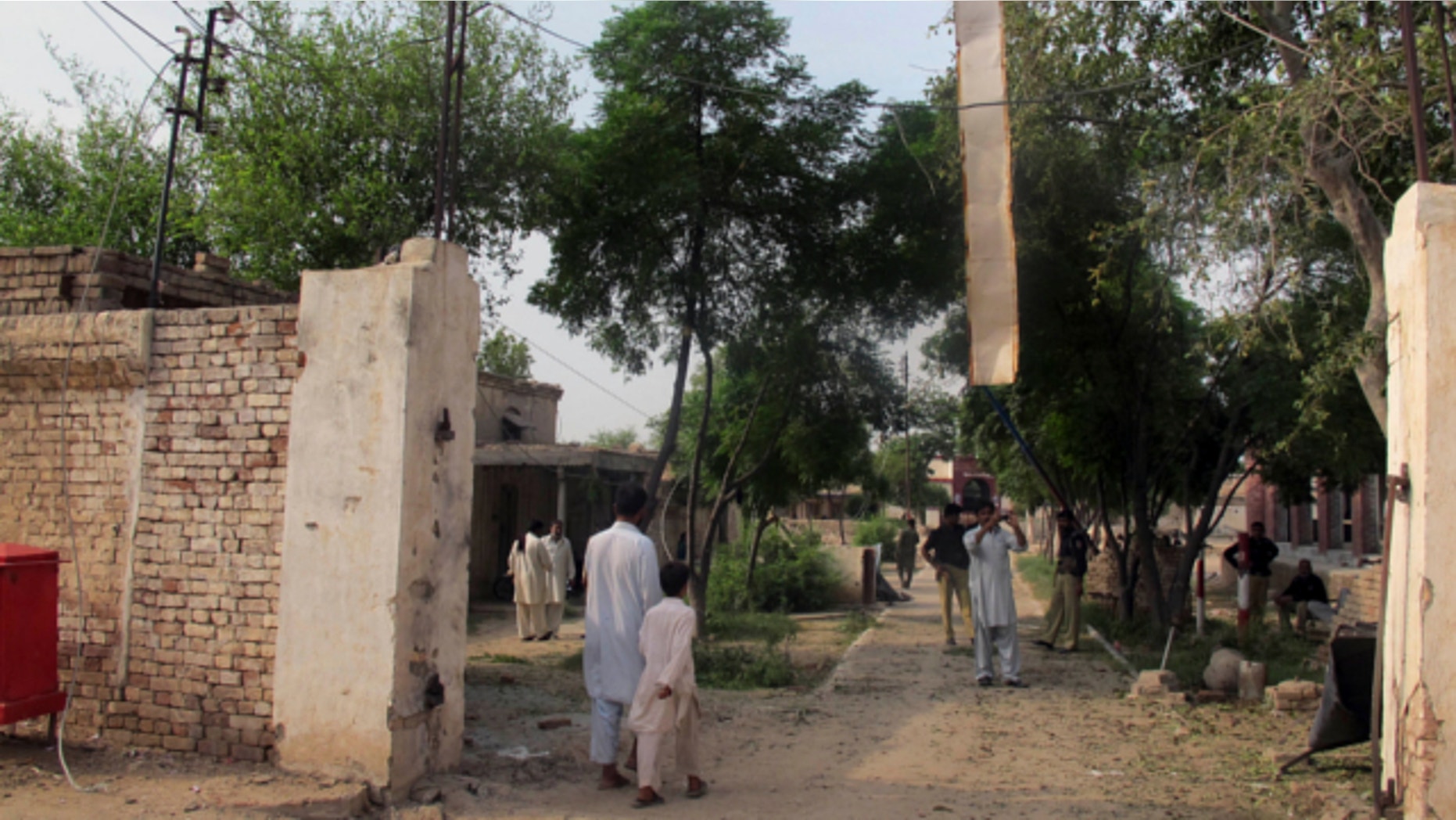 July 30, 2013: A plainclothes police officer takes a photo with his mobile phone of a damaged gate of center jail caused by Taliban militants attacked in Dera Ismail Khan, Pakistan.
