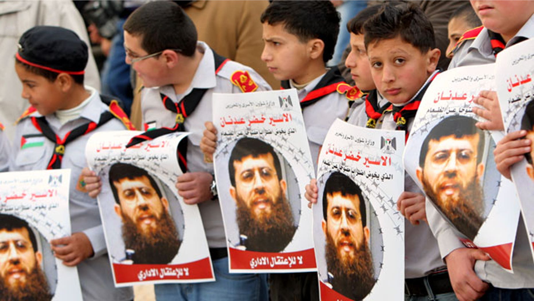 Feb. 9, 2012: Palestinian school-boys hold images of Khader Adnan, 33, a senior member of Islamic Jihad jailed in Israel who has been on hunger strike for 55 days, during a protest in solidarity with his action, and calling for the release of Palestinian prisoners jailed in Israel, in the West Bank city of Jenin.