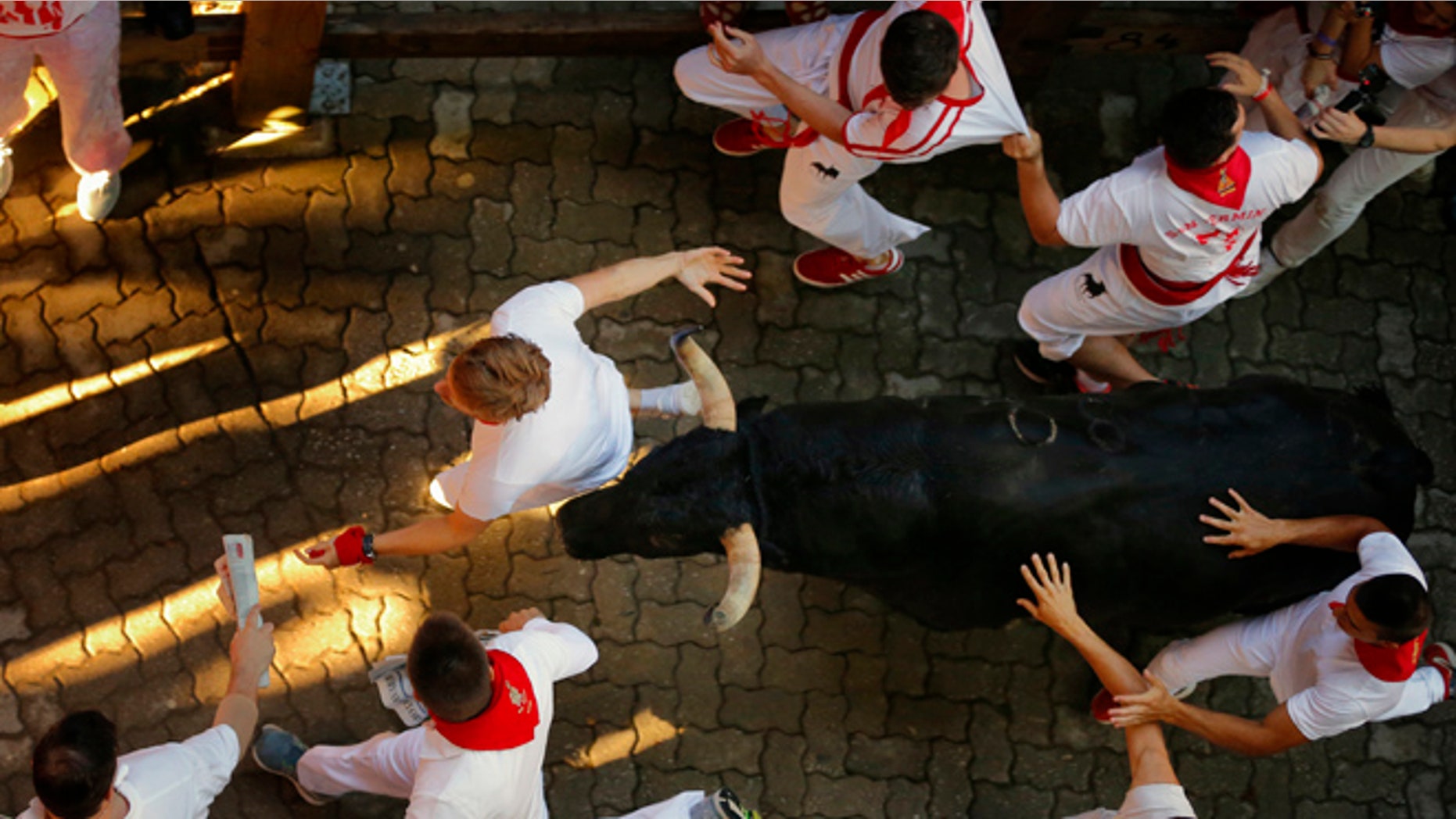 Revelers are chased by Fuente Ymbro's ranch fighting bulls in the 2016 San Fermin fiestas in Pamplona, Spain, Thursday, July 7, 2016. Revelers from around the world turned out here to kick off the festival with a messy party in the Pamplona town square, one day before the first of eight days of the running of the bulls. (AP Photo/Daniel Ochoa de Olza)